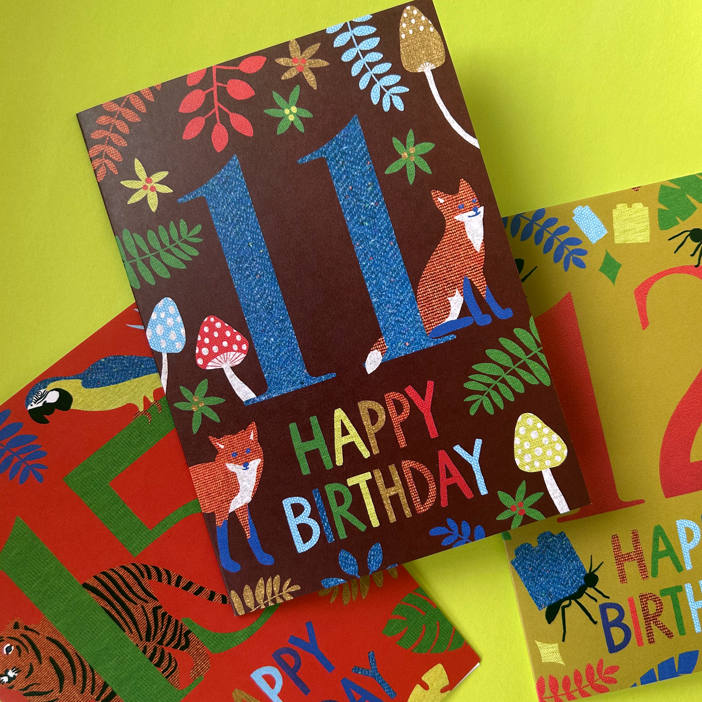 Colorful birthday cards with animal illustrations on a green background