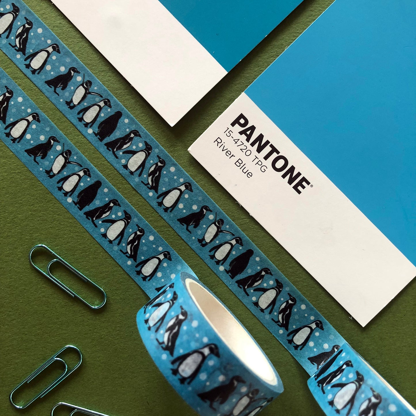 Image shows a blue washi tape with a fun penguin and snowball print