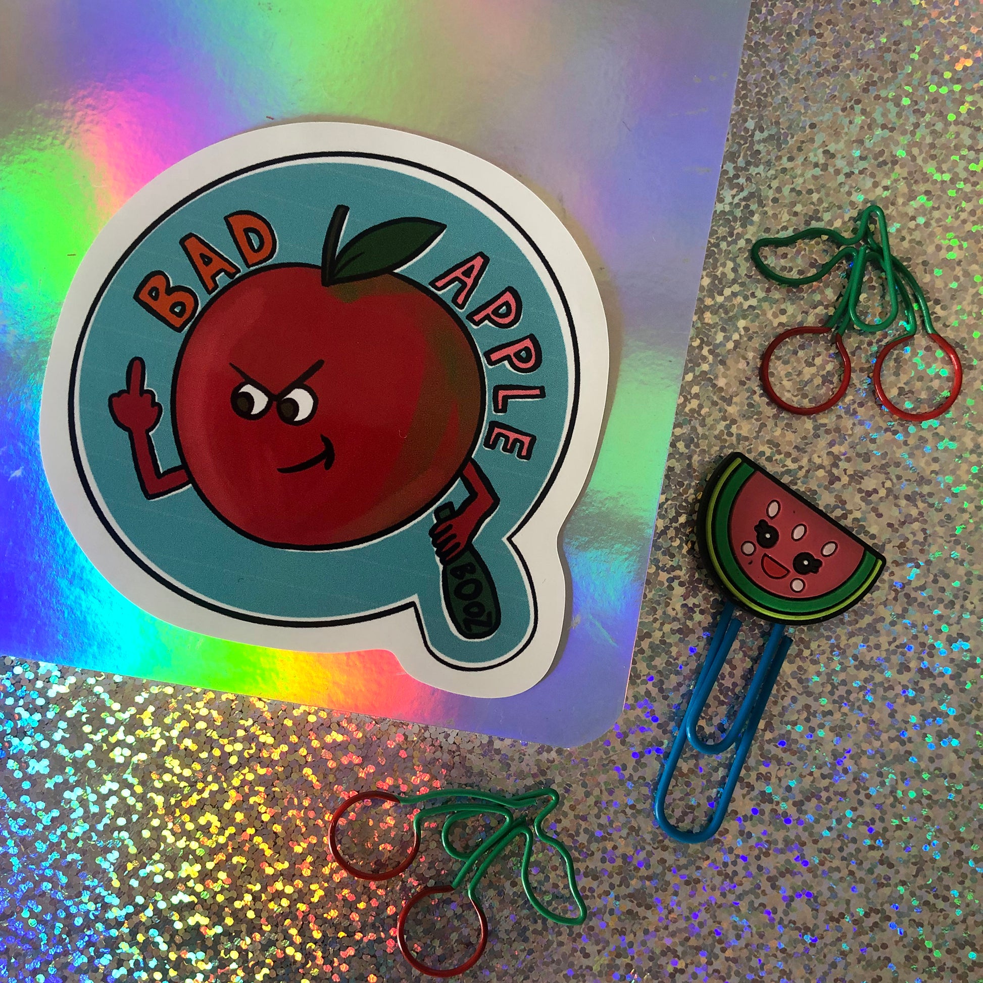 Image shows a vinyl sticker featuring a red apple swearing and drinking with the wording 'Bad Apple'