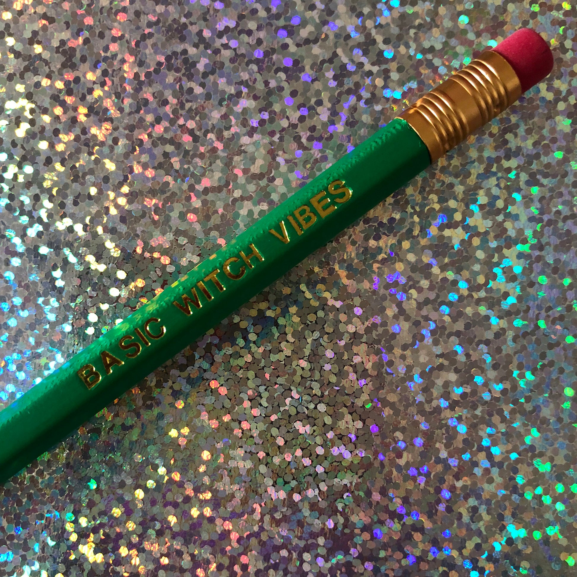 Image of a green pencil with 'Basic Witch Vibes' embossed in gold lettering