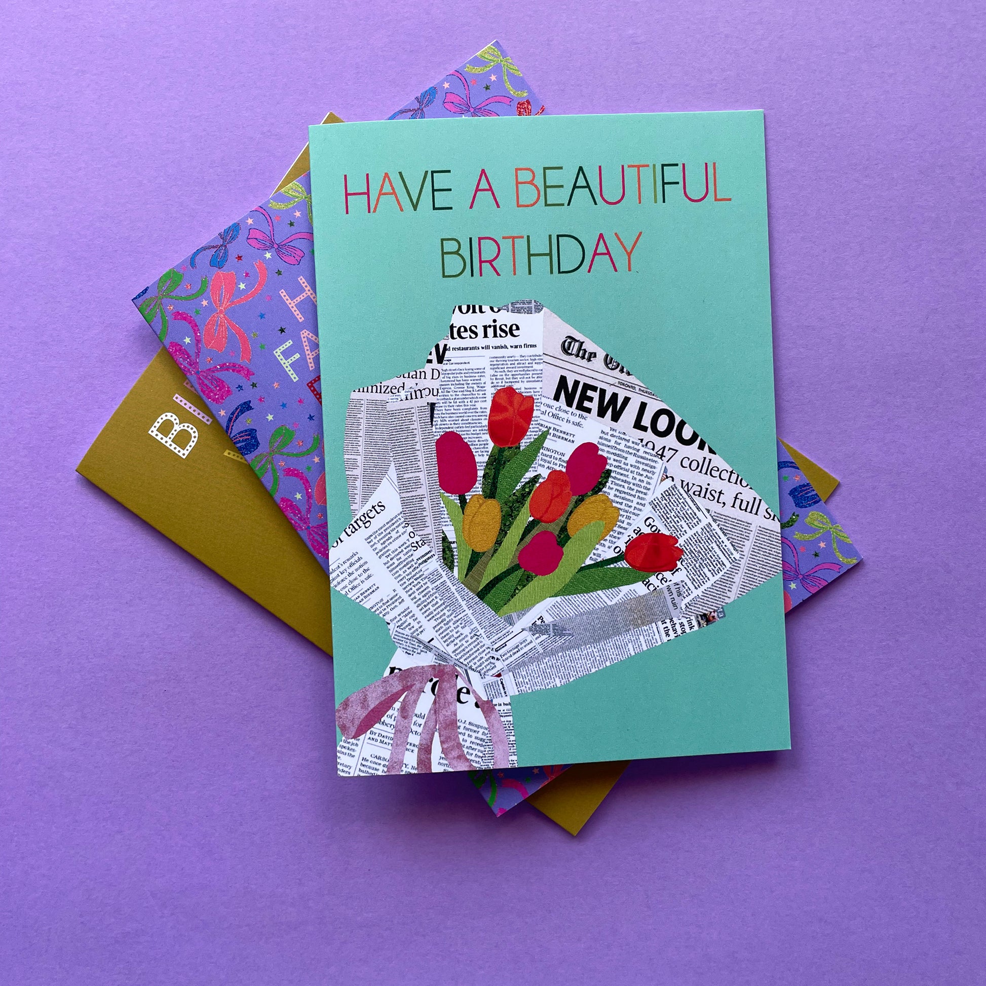 Image of a pastel green card that reads Have a Beautiful Birthday and features a unique, collaged illustration of a bouquet of tulips in newspaper.