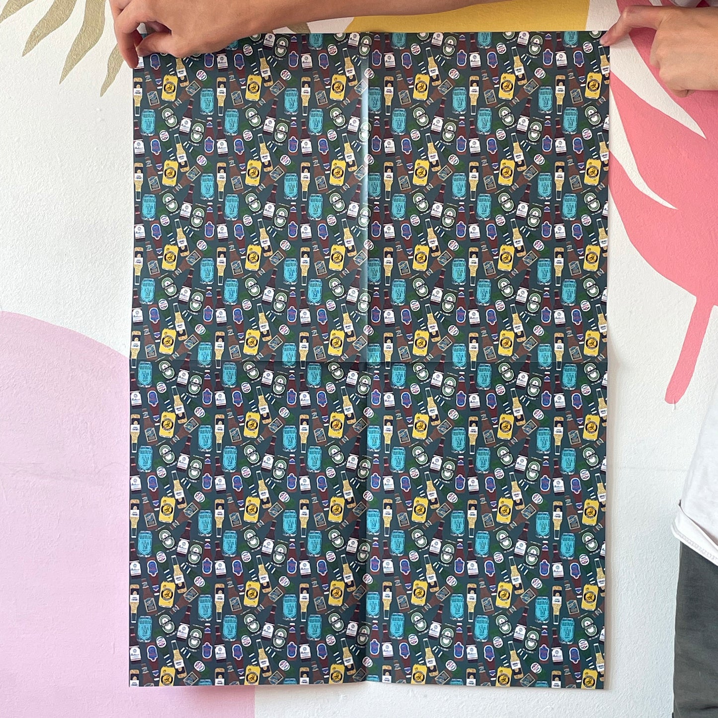 Image shows a green blue gift wrap with illustrations of different beers patterned design