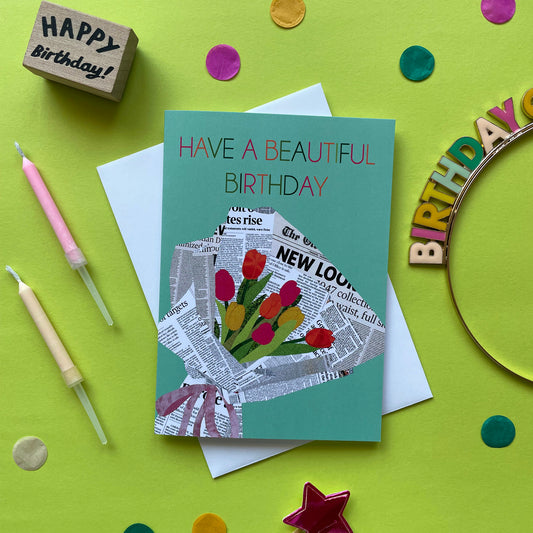 Image of a pastel green card that reads Have a Beautiful Birthday and features a unique, collaged illustration of a bouquet of tulips in newspaper.