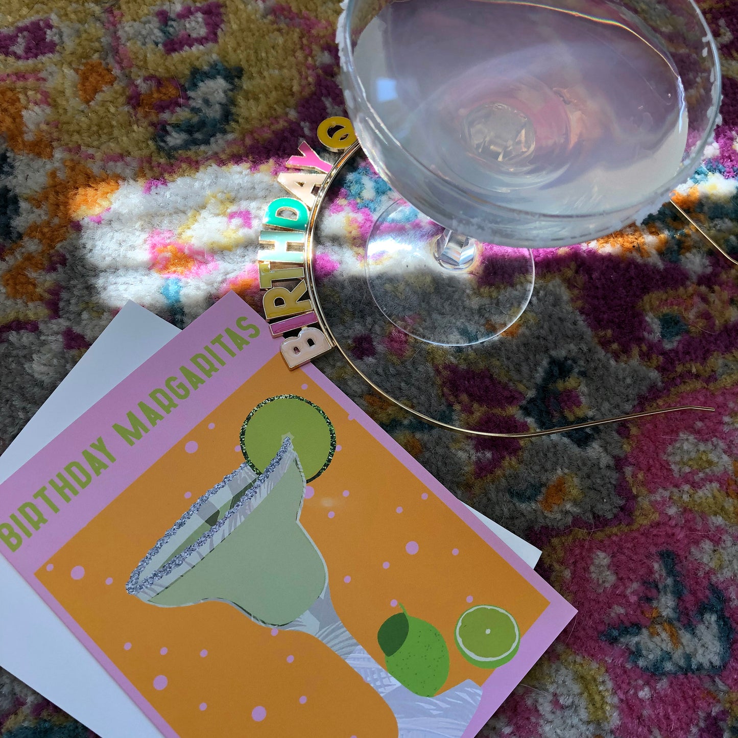 Image shows a yellow and pink coloured birthday card with the greeting 'Birthday Margaritas' and a lime green cocktail with limes and a glitter salt rim.