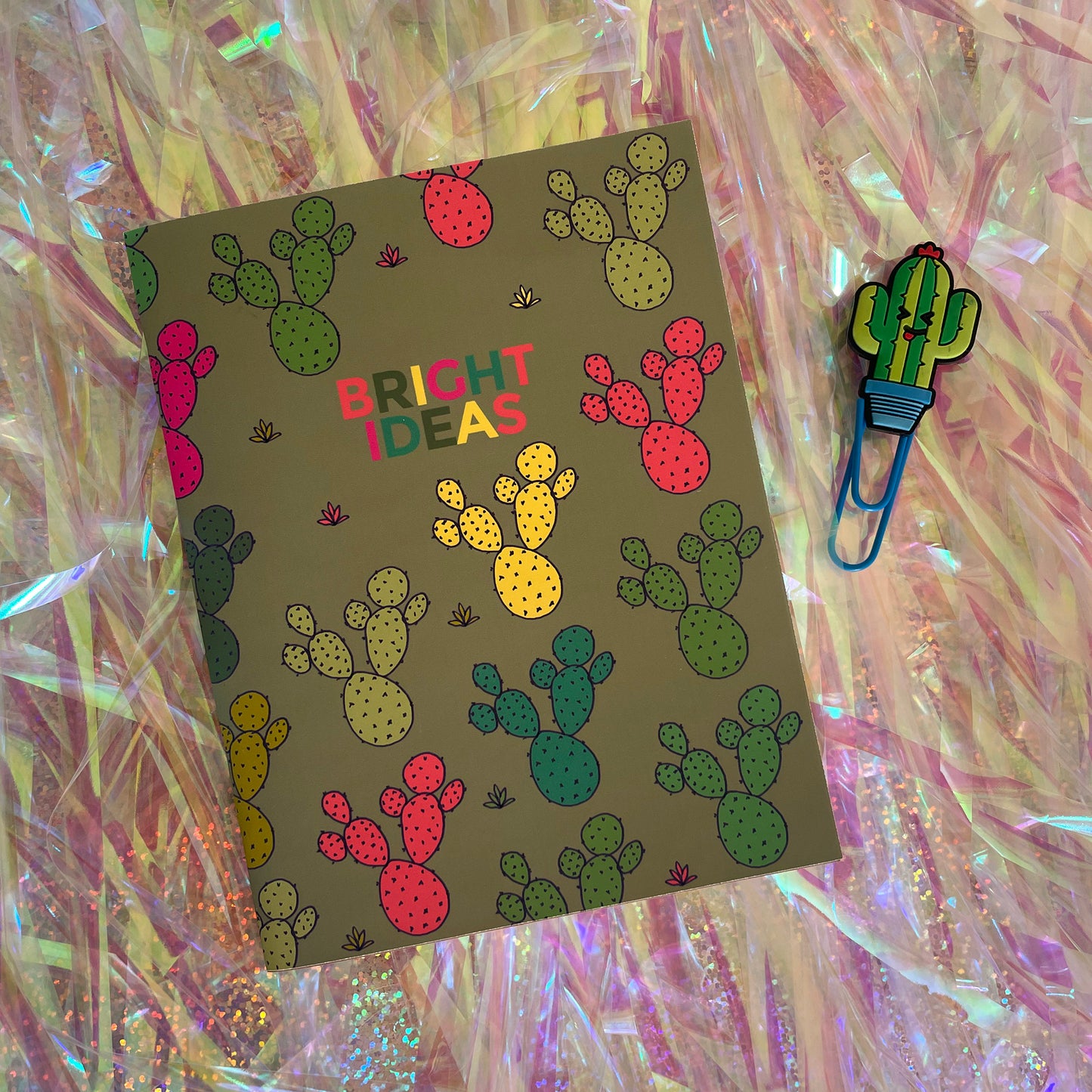 Image shows a pocket size green notebook with a neon cactus print and 'Bright Ideas' written on the front.