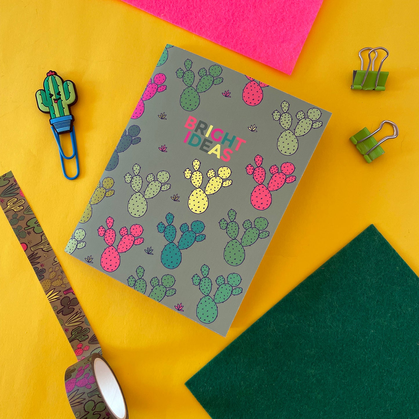 Image shows a pocket size green notebook with a neon cactus print and 'Bright Ideas' written on the front.