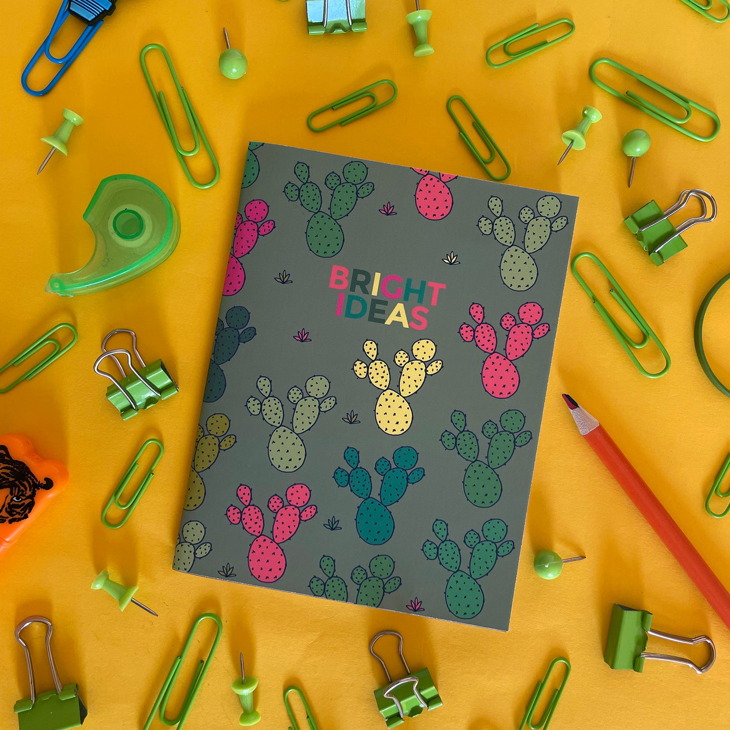 Image shows a pocket size green notebook with a neon cactus print and 'Bright Ideas' written on the front.