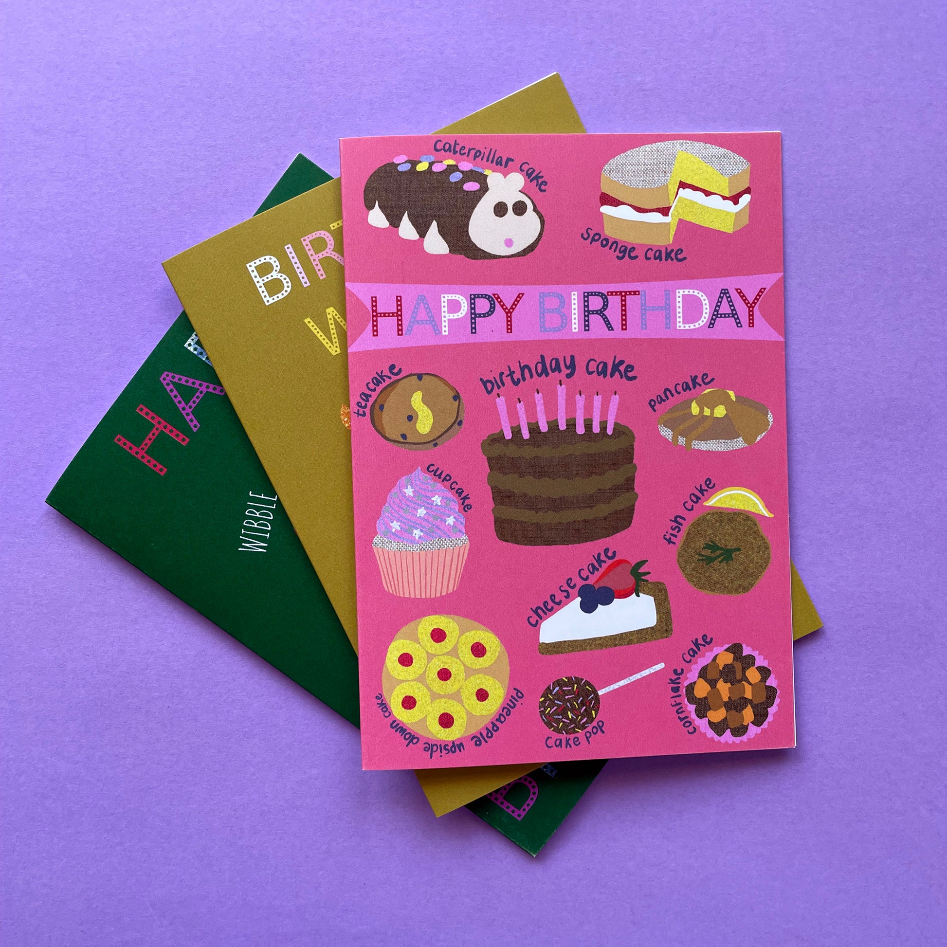 Image shows a pink birthday card with illustrations of different sorts of cakes and the words Happy Birthday