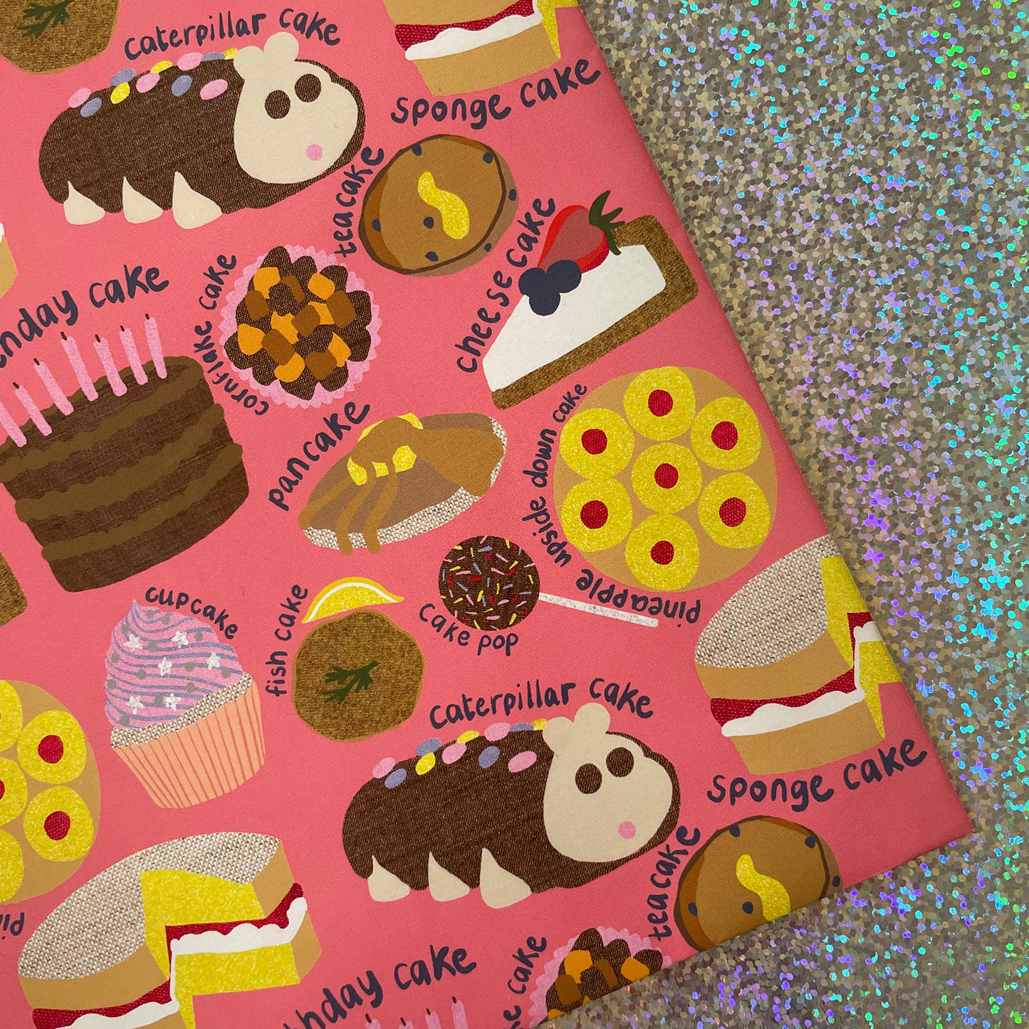 Image shows a pink gift wrap with a fun cake pattern