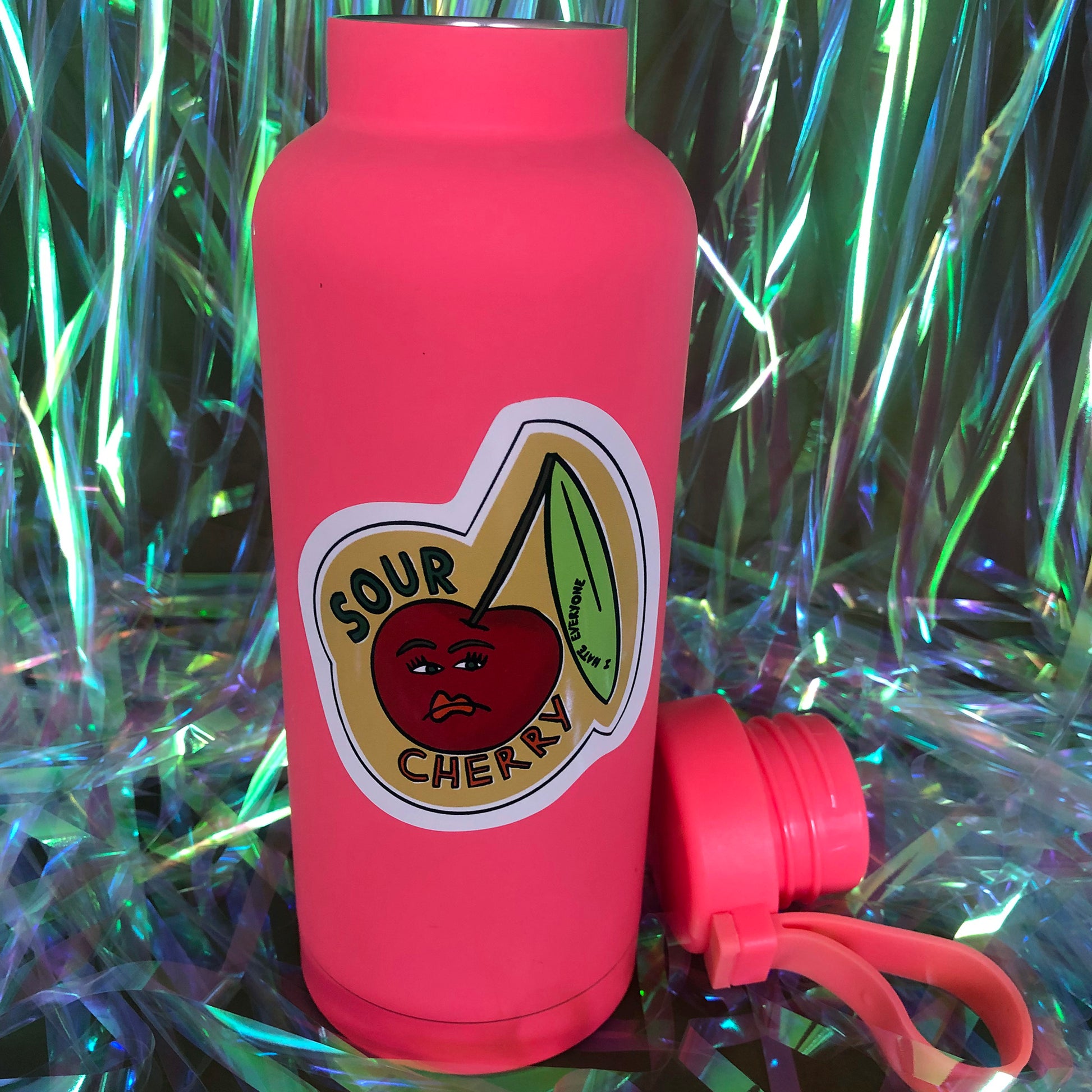 Image shows a vinyl sticker featuring an illustration of an unhappy looking cherry and the wording 'Sour Cherry'