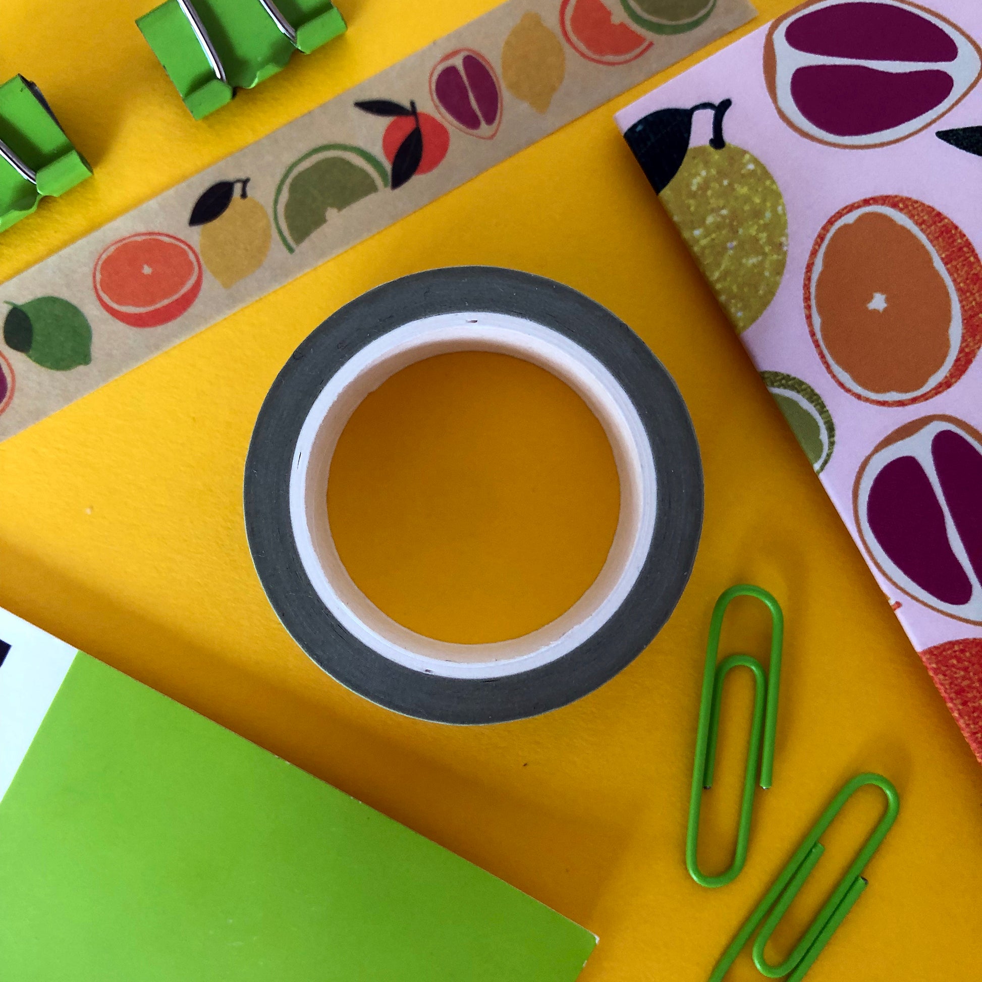 Image shows a pale green washi tape with a colourful citrus fruit print