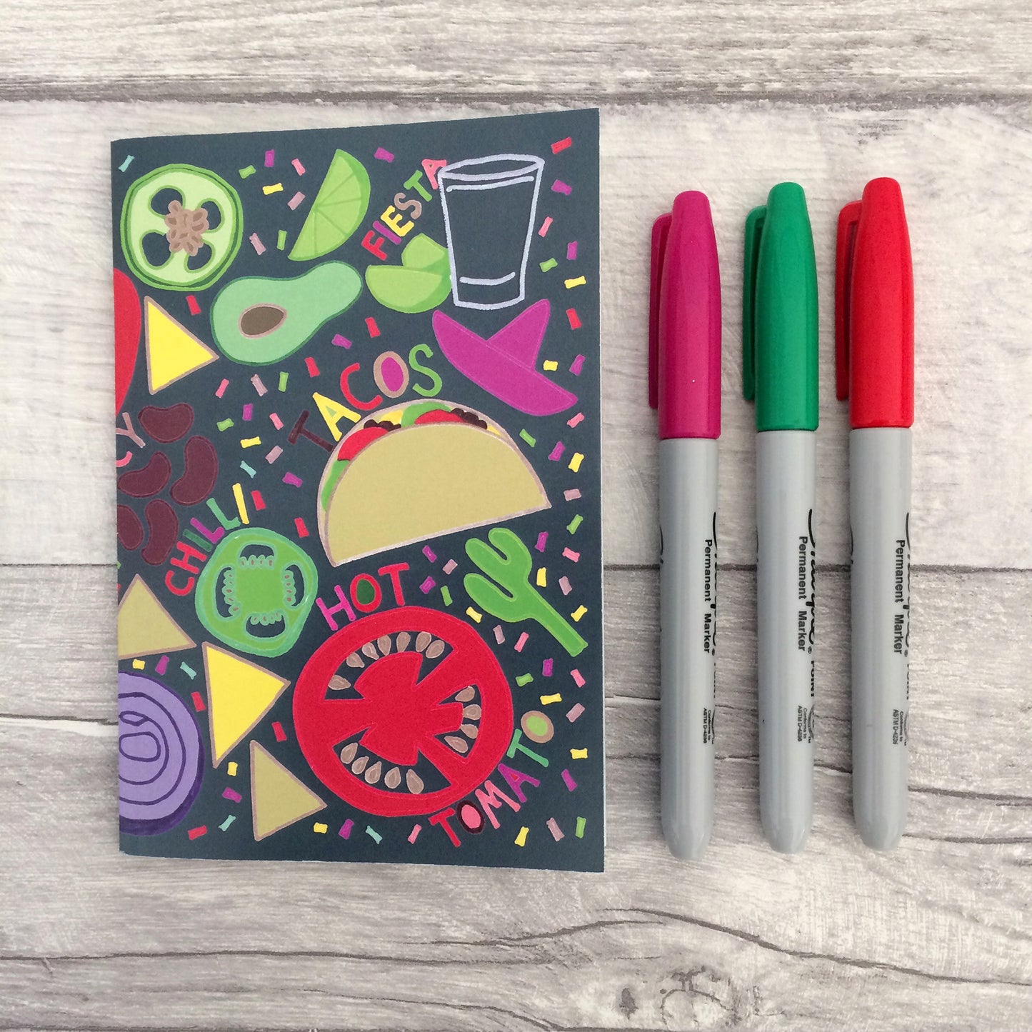 Image shows a bright and colourful notebook with illustrations of mexican food ingredients, words and confetti in a hand drawn style