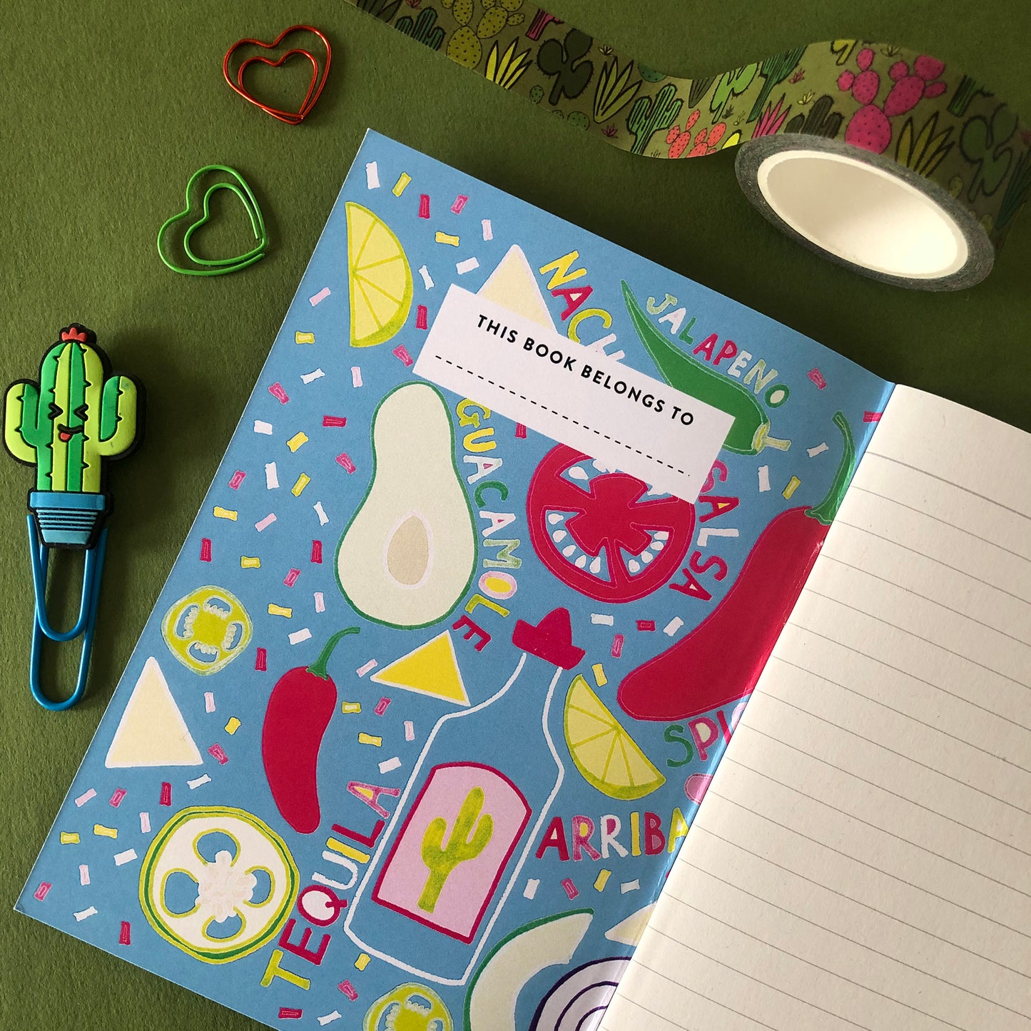 Image shows a bright and colourful notebook with illustrations of mexican food ingredients, words and confetti in a hand drawn style on the inside cover and lined pages