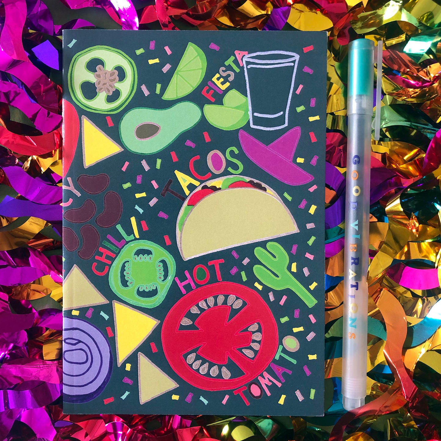 Image shows a bright and colourful notebook with illustrations of mexican food ingredients, words and confetti in a hand drawn style