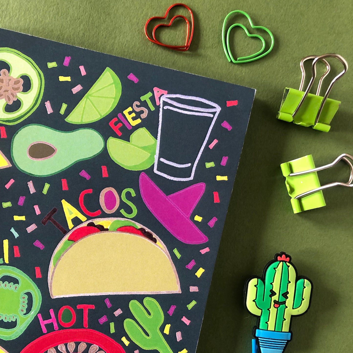 Image shows a bright and colourful notebook with illustrations of mexican food ingredients, words and confetti in a hand drawn style
