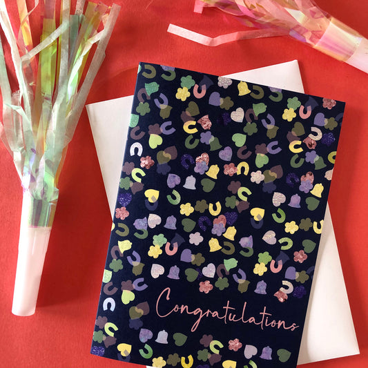 Image shows a navy blue card with a confetti print pattern and 'Congratulations' in pink writing