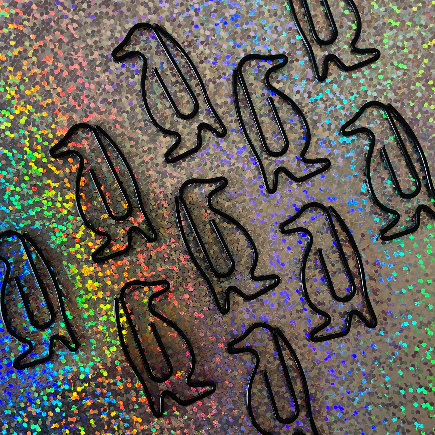 Image shows a set of black penguin shaped paperclips.