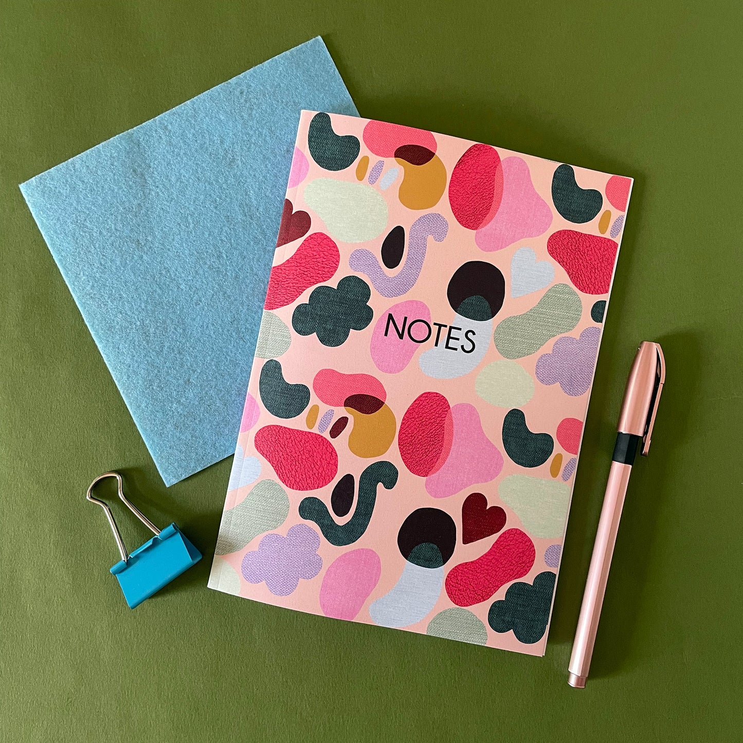 Image of a colourful notebook with a textured shapes pattern in bright colours and the word notes in black.