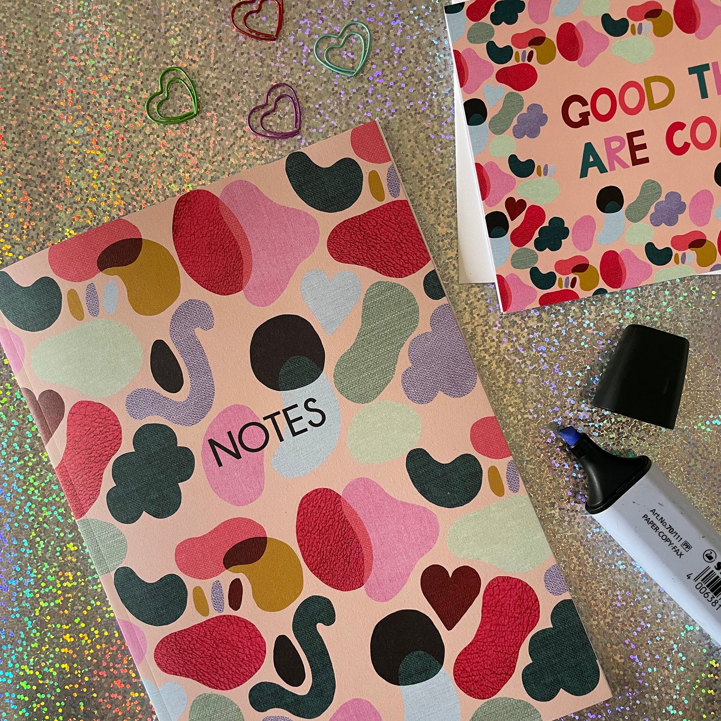 Image of a colourful notebook with a textured shapes pattern in bright colours and the word notes in black.