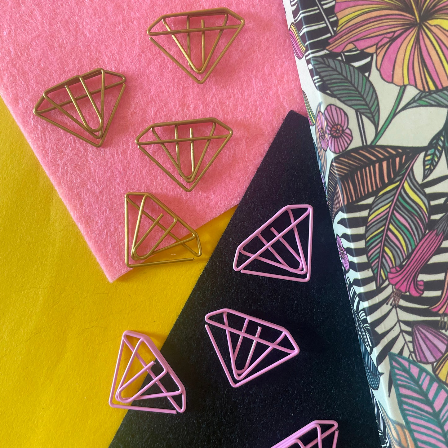 Image shows a set of pink and gold, diamond shaped paperclips.