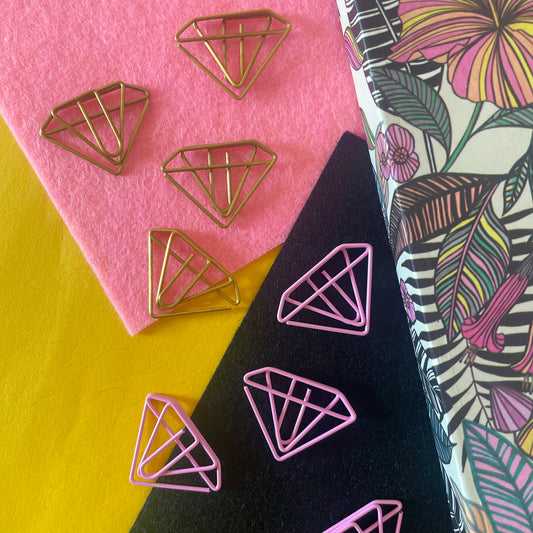 Image shows a set of pink and gold, diamond shaped paperclips.