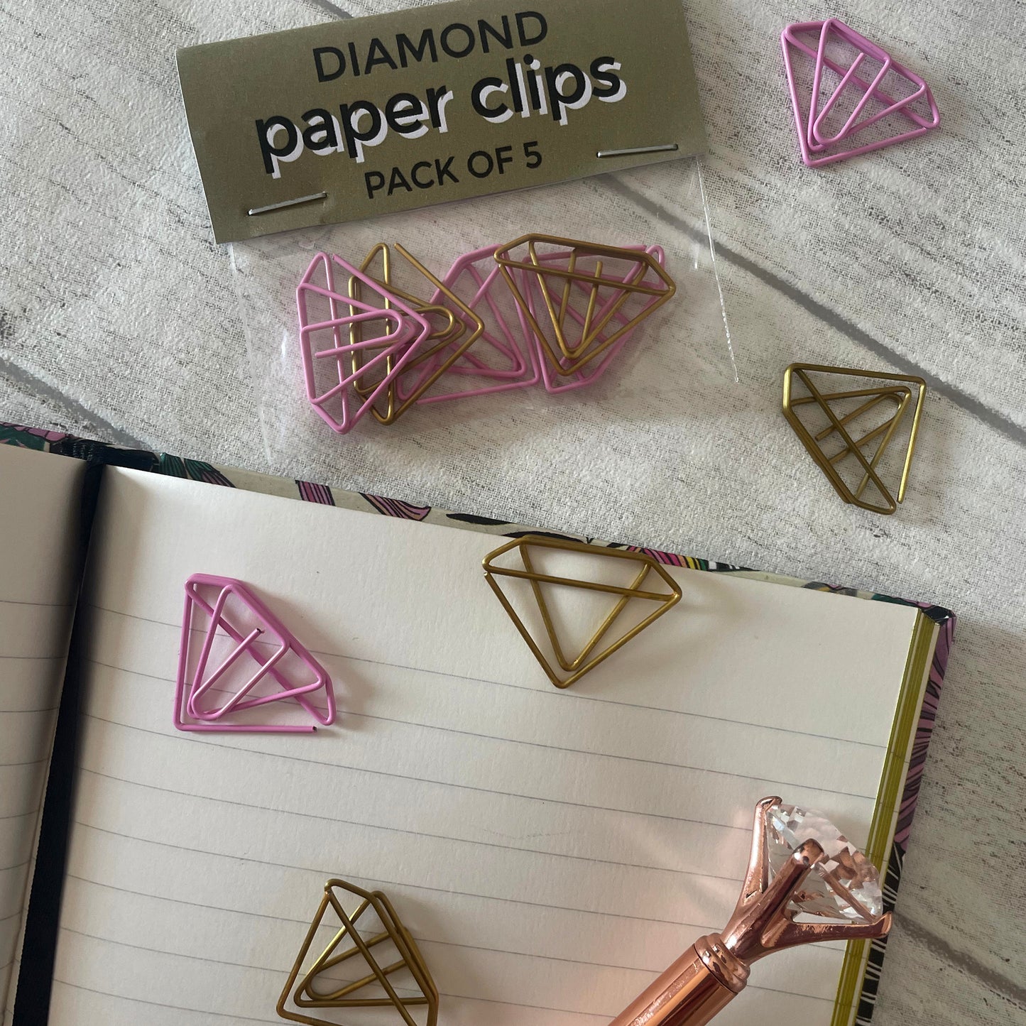 Image shows a set of pink and gold, diamond shaped paperclips.