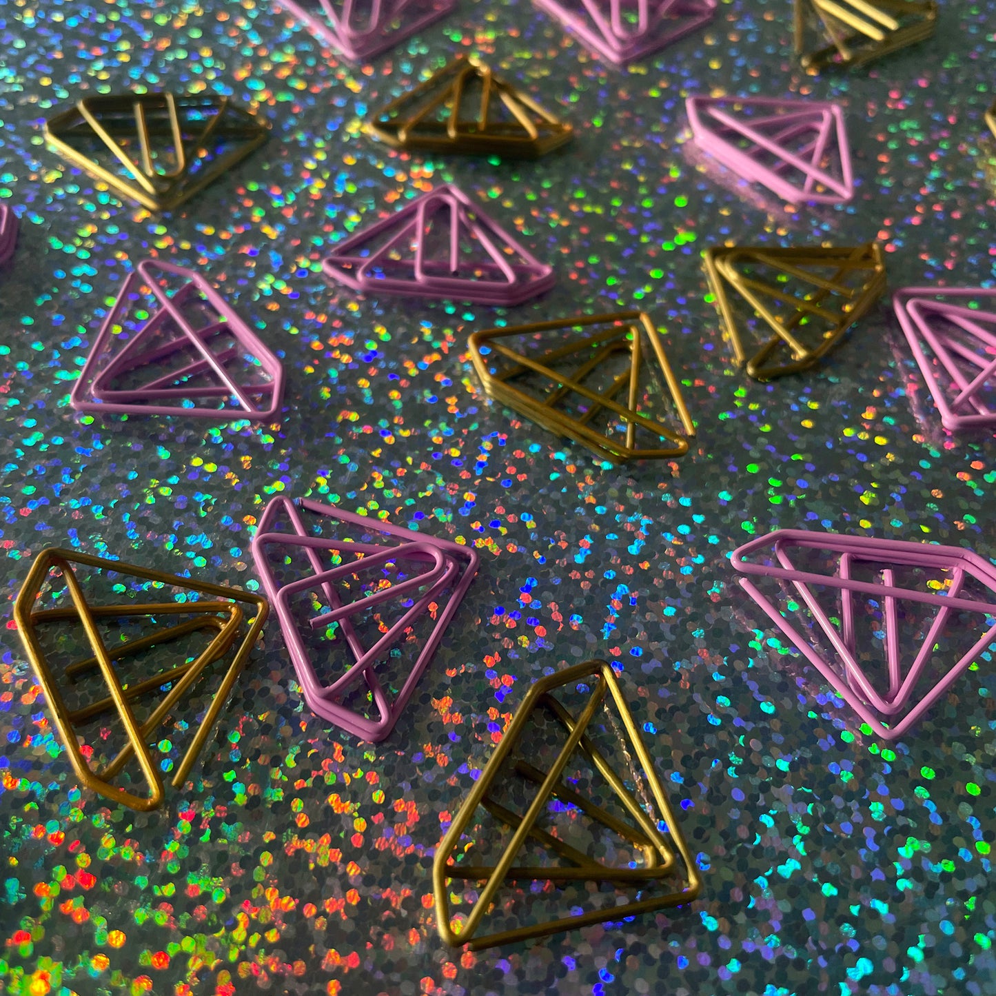 Image shows a set of pink and gold, diamond shaped paperclips.