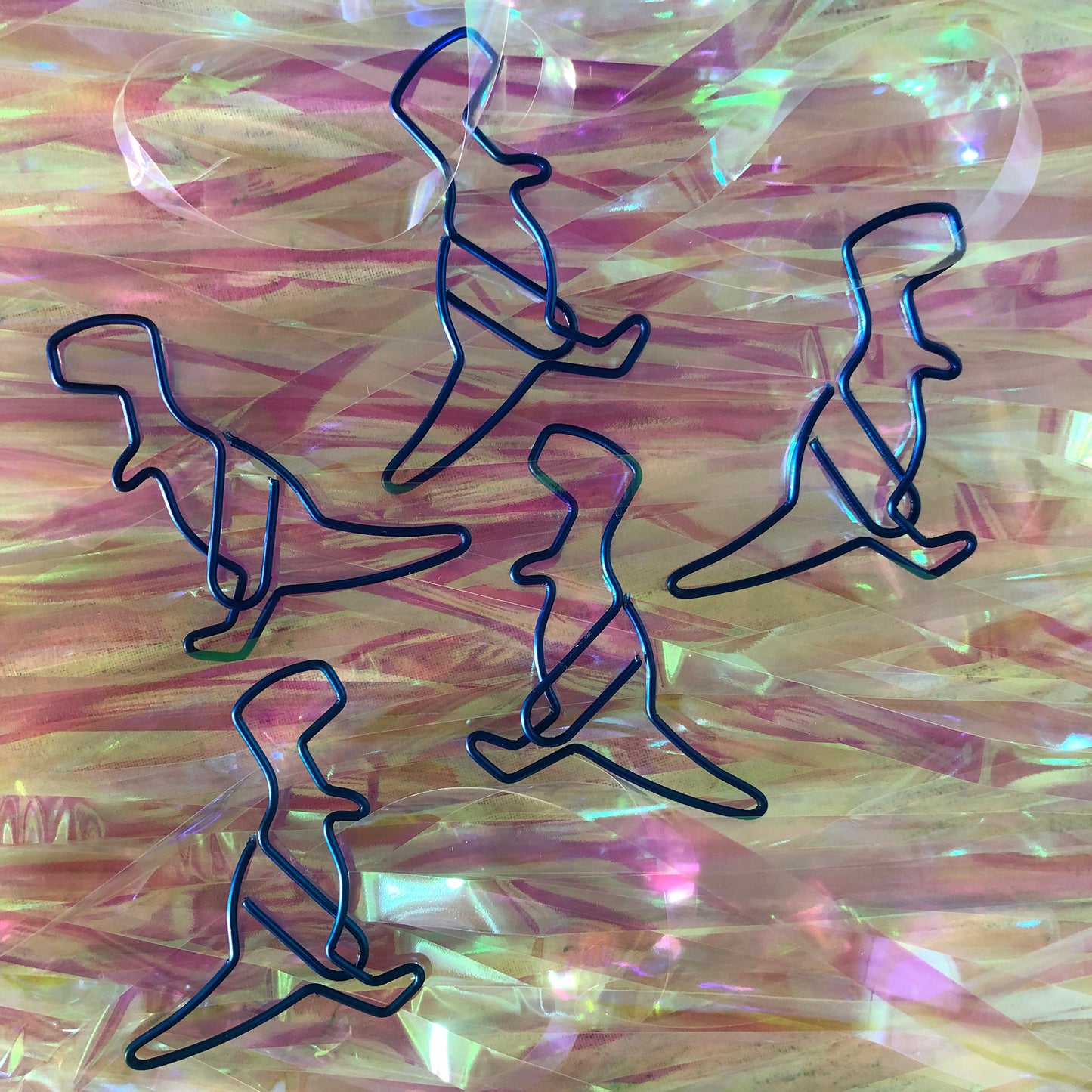 Image shows a set of metallic blue dinosaur shaped paperclips.