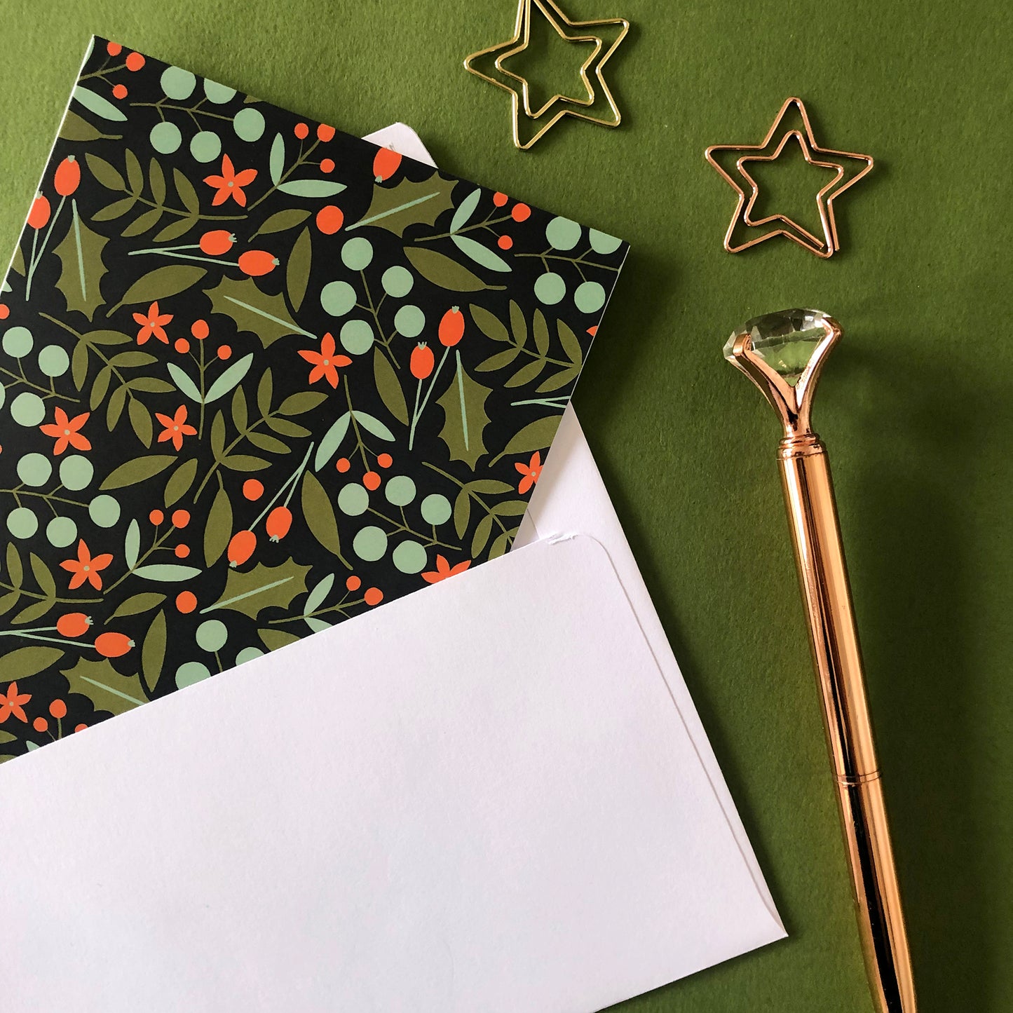 Image shows a festive nature christmas card featuring a leaves and berries pattern.