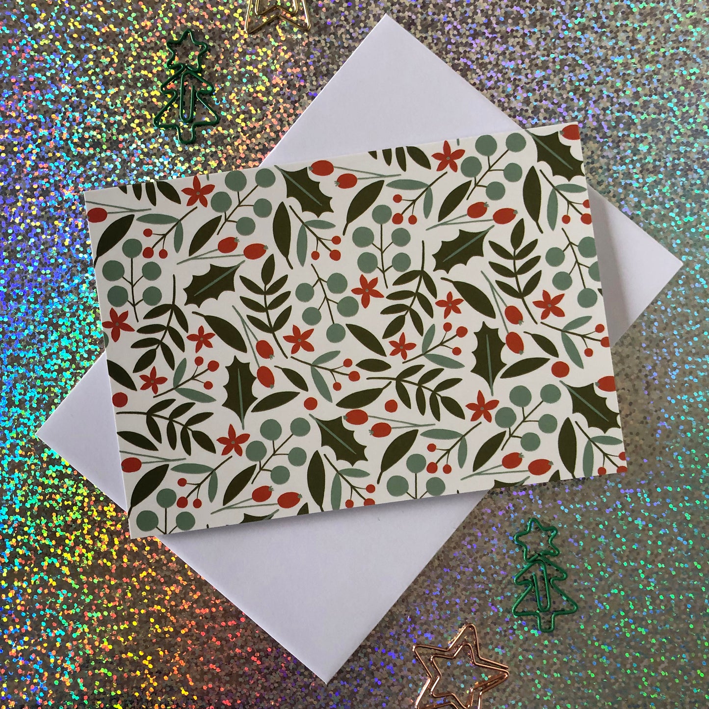 Image shows a festive nature christmas card featuring a leaves and berries pattern.