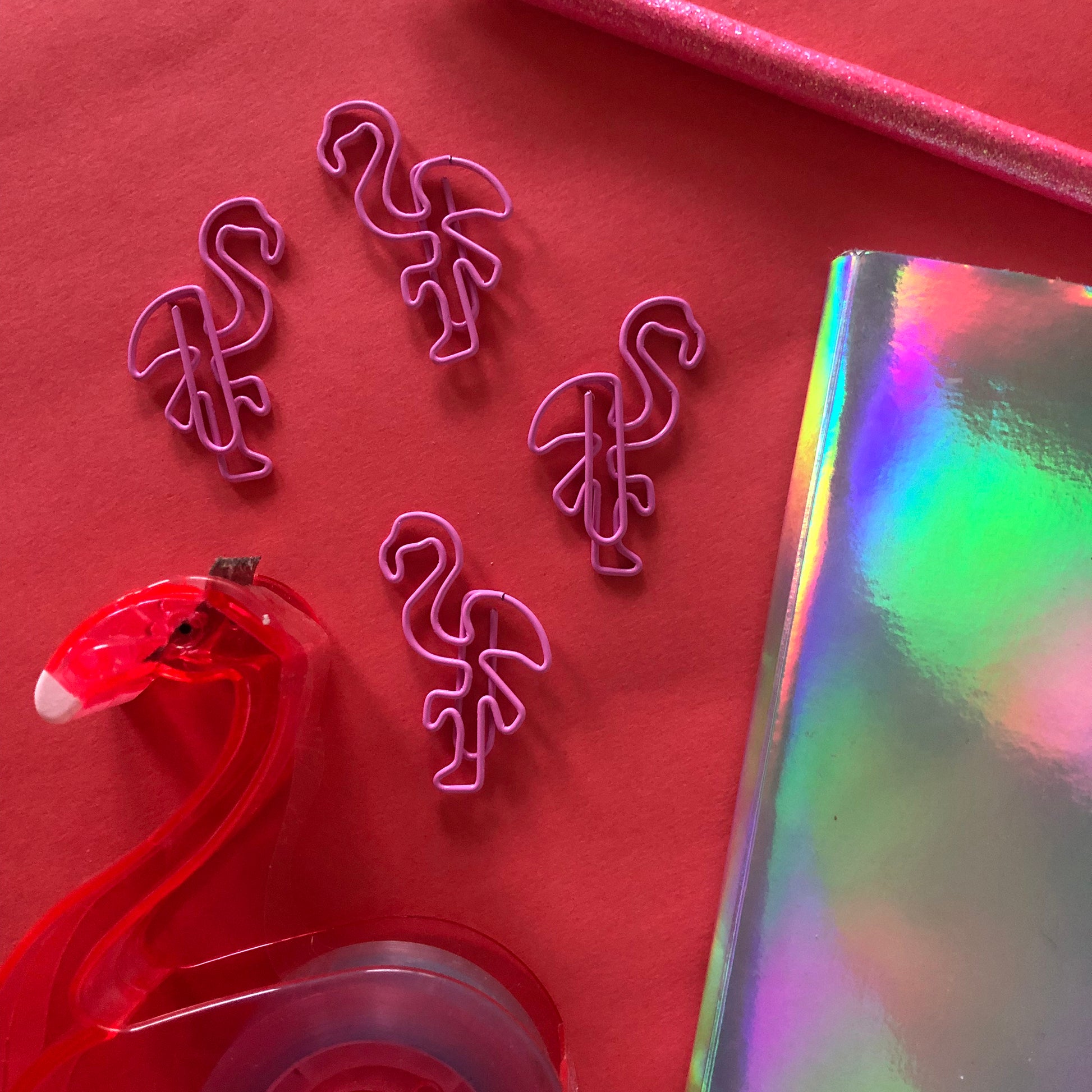 Image shows a set of pink flamingo shaped paperclips.