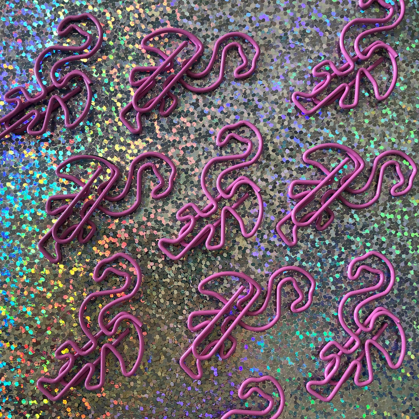 Image shows a set of pink flamingo shaped paperclips.