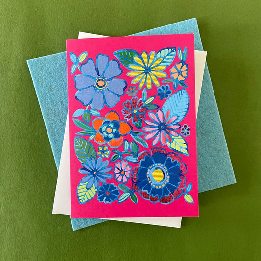 Image shows a bright pink greetings card with a floral illustration in blue ink with colourful collaged detail