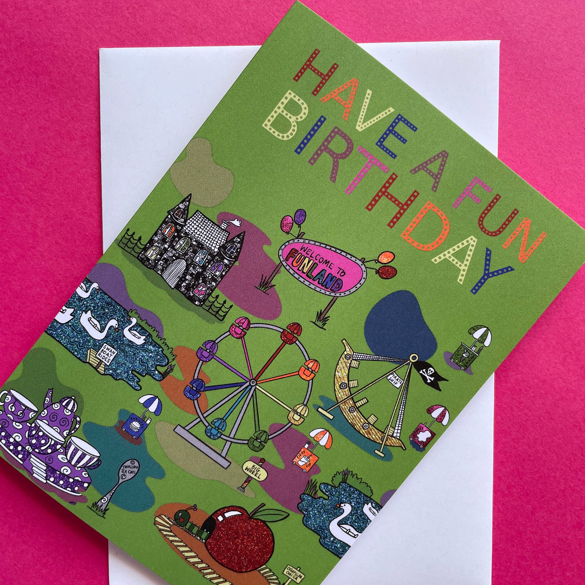 Image shows a green birthday card with illustrations of  vintage theme park rides and the words Have a Fun Birthday