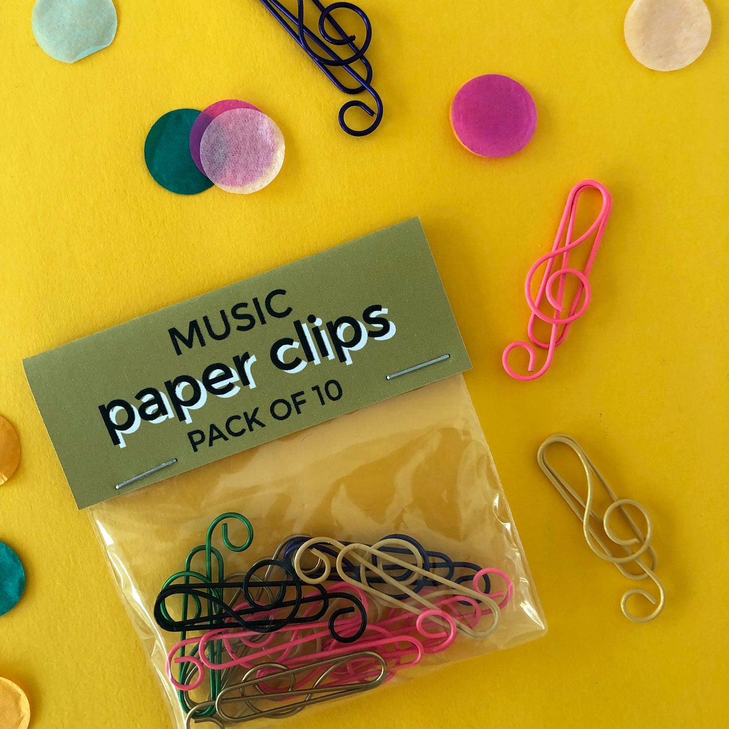 Image shows a set of pink, black and gold, treble clef shaped paperclips.