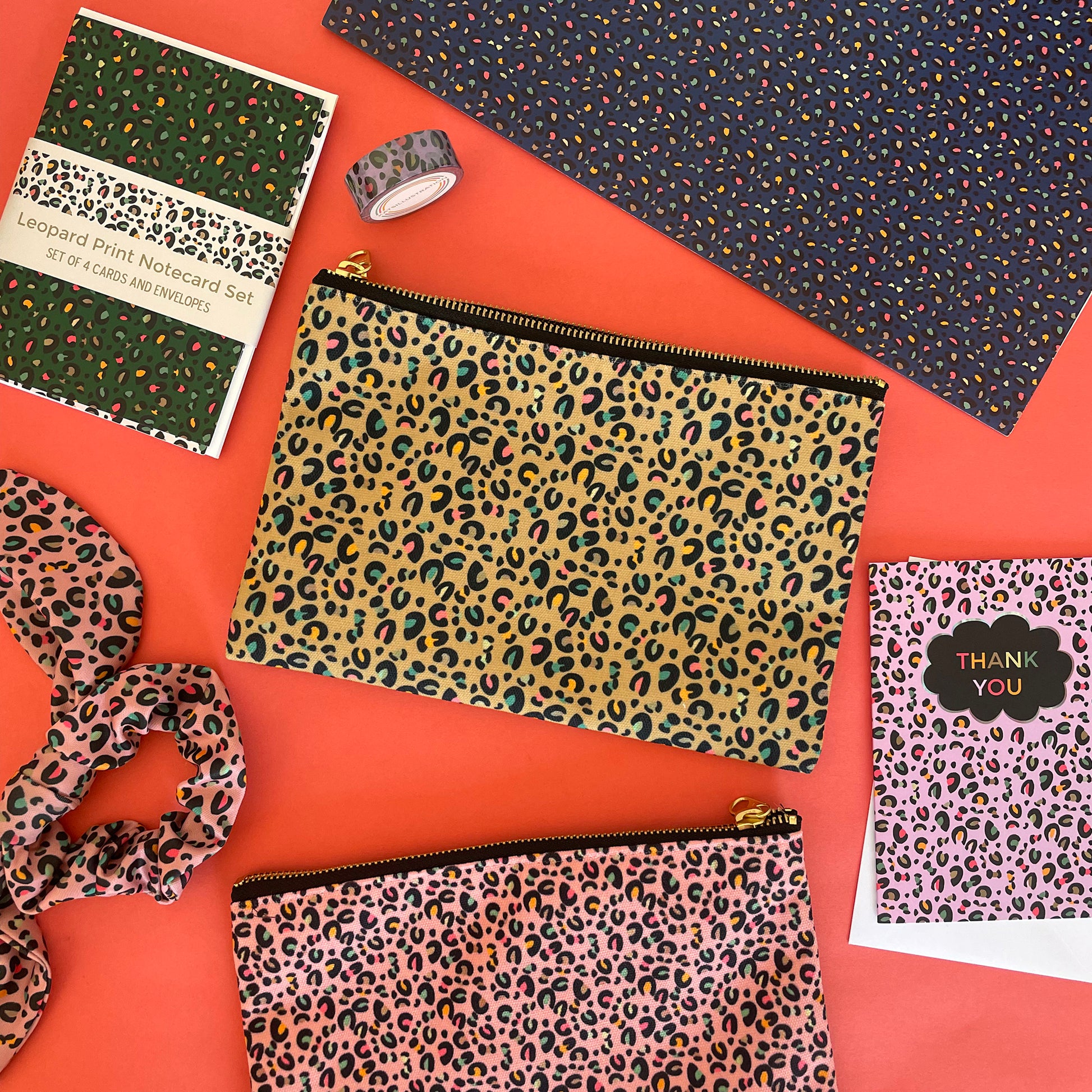 Image shows a beautiful leopard print zip pouch in gold on a red background with accessories.