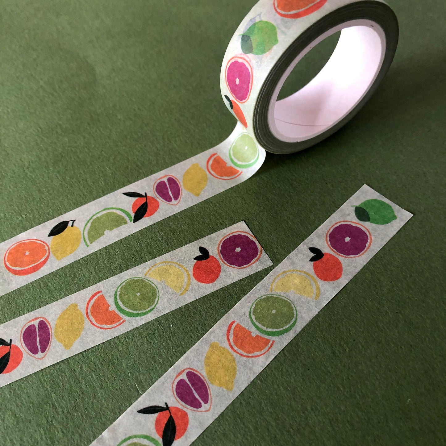 Image shows a pale green washi tape with a colourful citrus fruit print