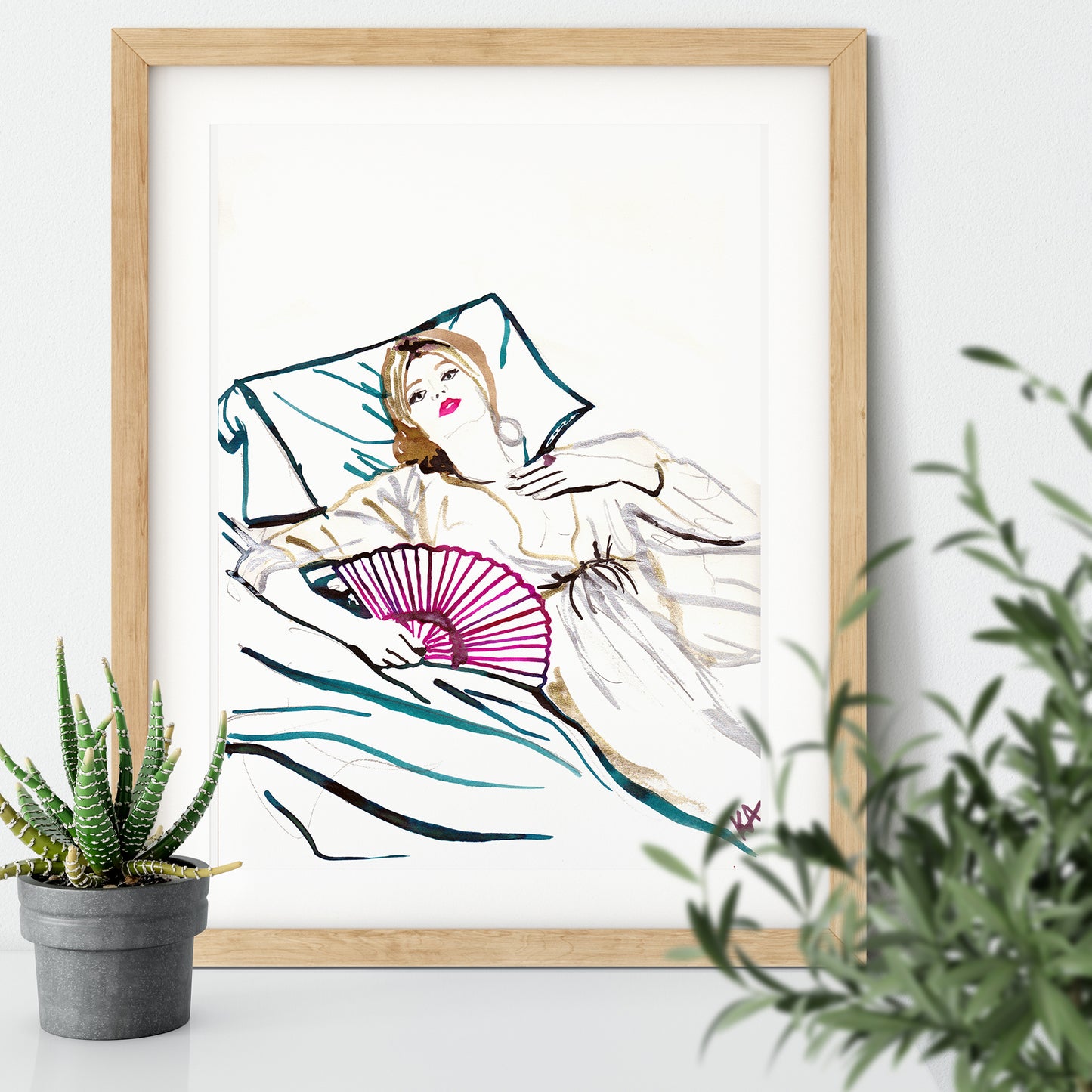 Image of a framed piece of art. An ink illustration of a woman lying on a bed with a fan. Hand drawn in drawing inks.