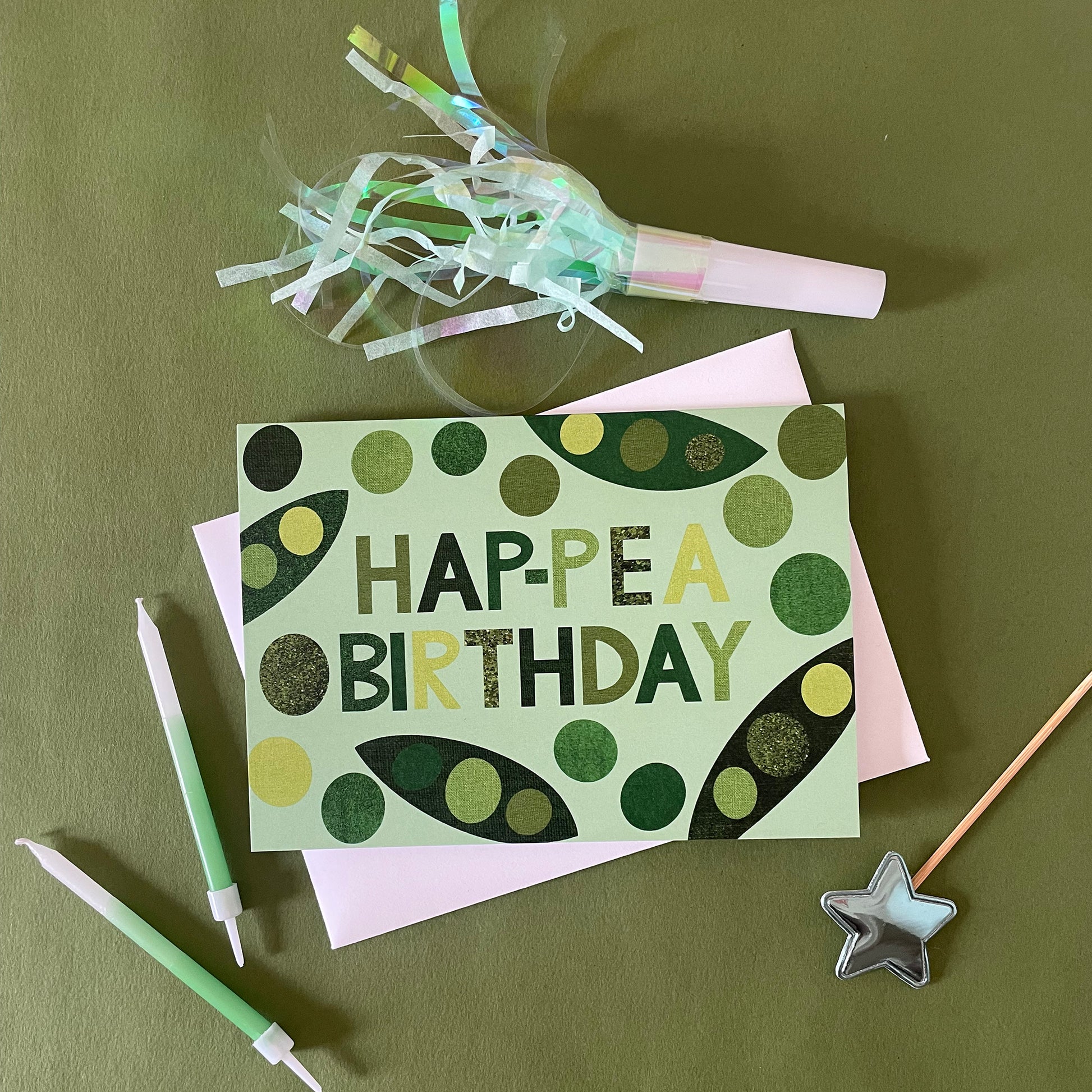 Image of a light green card that says Hap-pea Birthday in bold lettering and has collaged illustrations of peas and pods