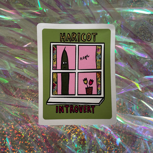 Image shows a green, rectangular sticker with an illustration of a green bean looking out of a window and the words 'Haricot Introvert'