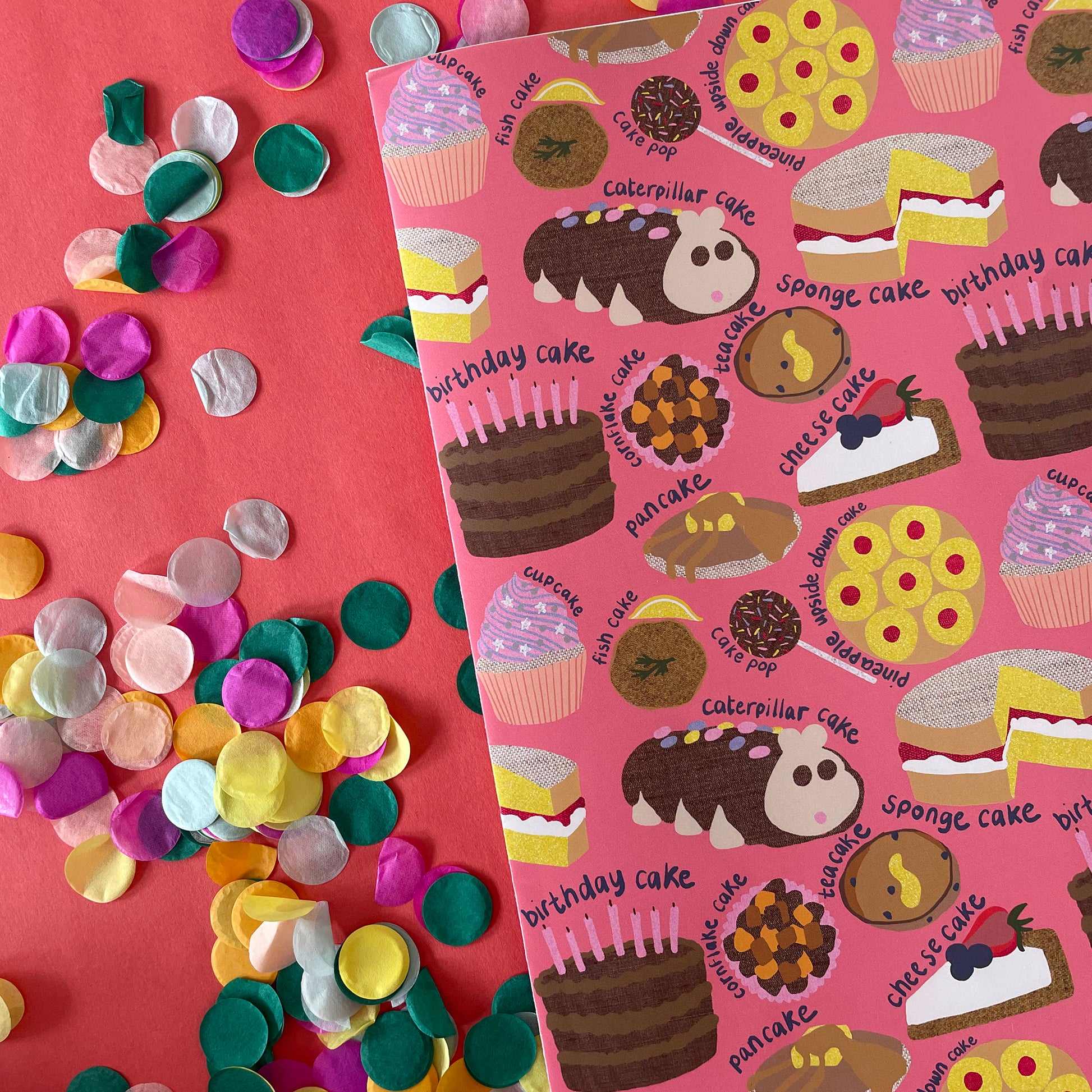 Image shows a pink gift wrap with a fun cake pattern
