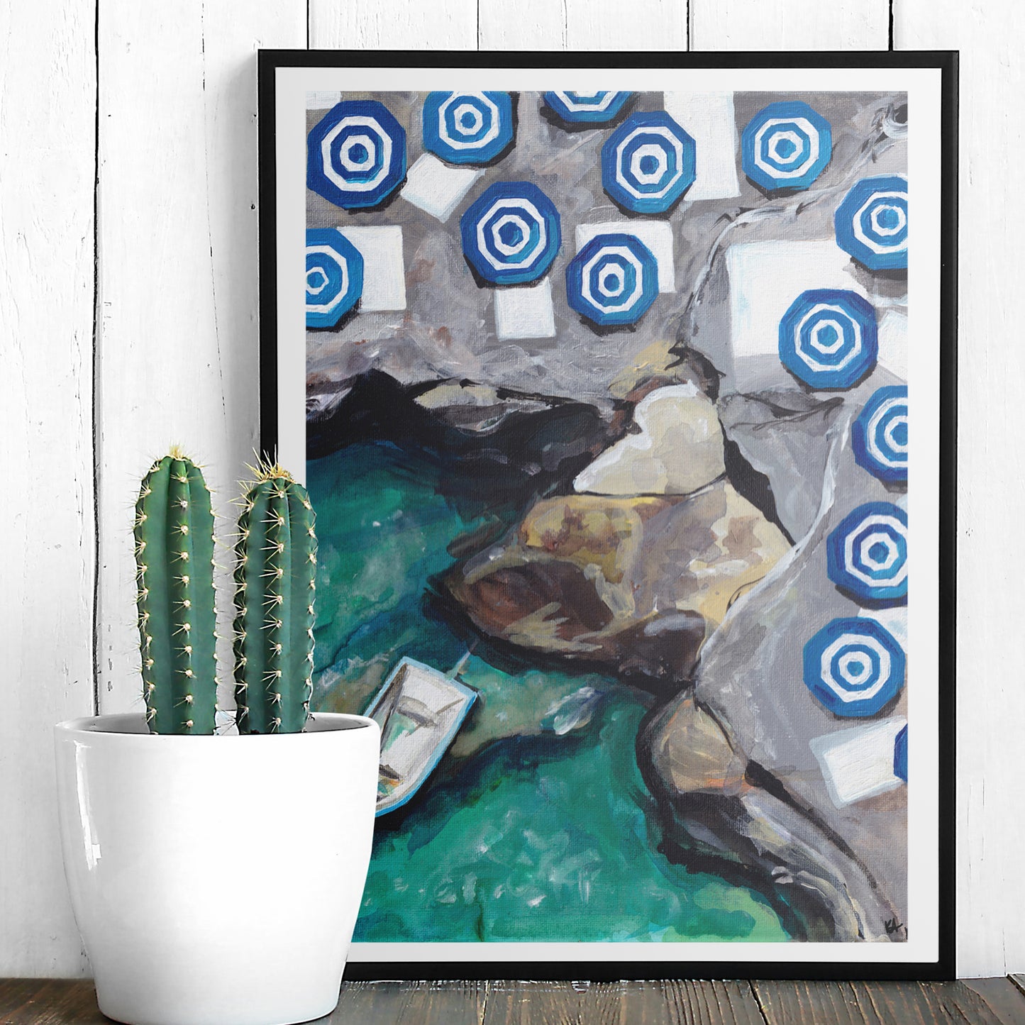 Image of a framed print of a painting of capri featuring striped umbrellas and aqua water with rocks and a small boat.