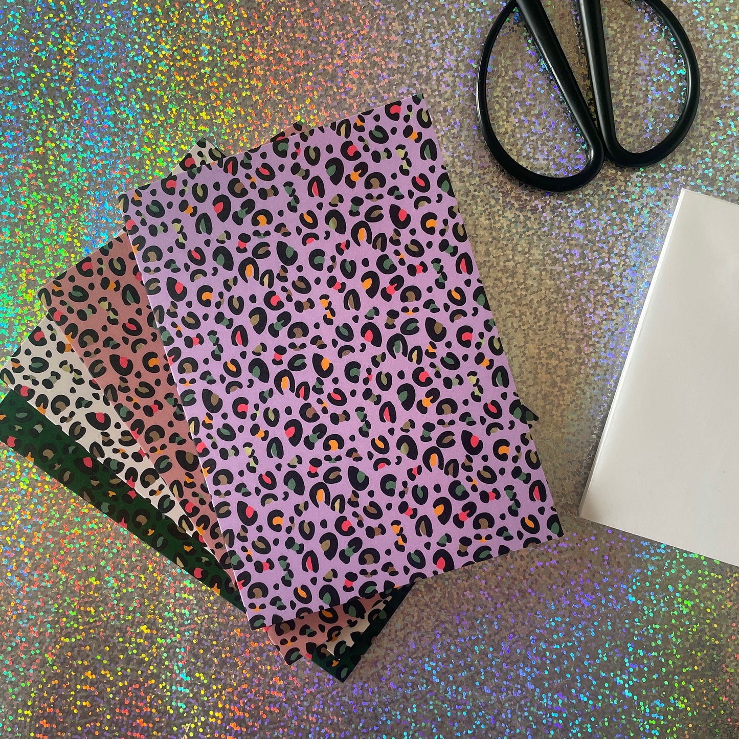 Image shows a set of 4 leopard print notecards each in a different fun colour with pops of neon in the pattern