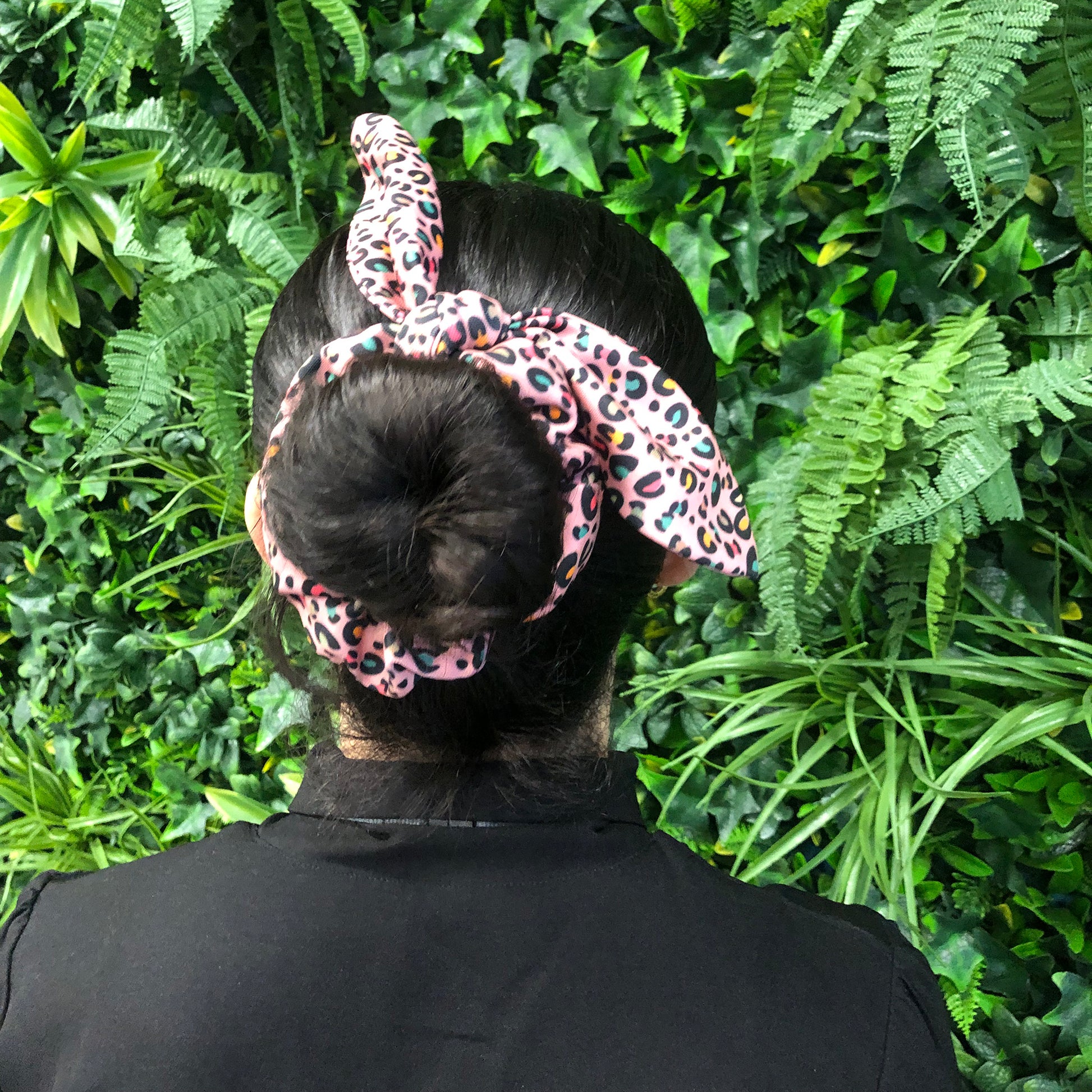 Image shows a pink leopard print hair scrunchie with a knot and bow