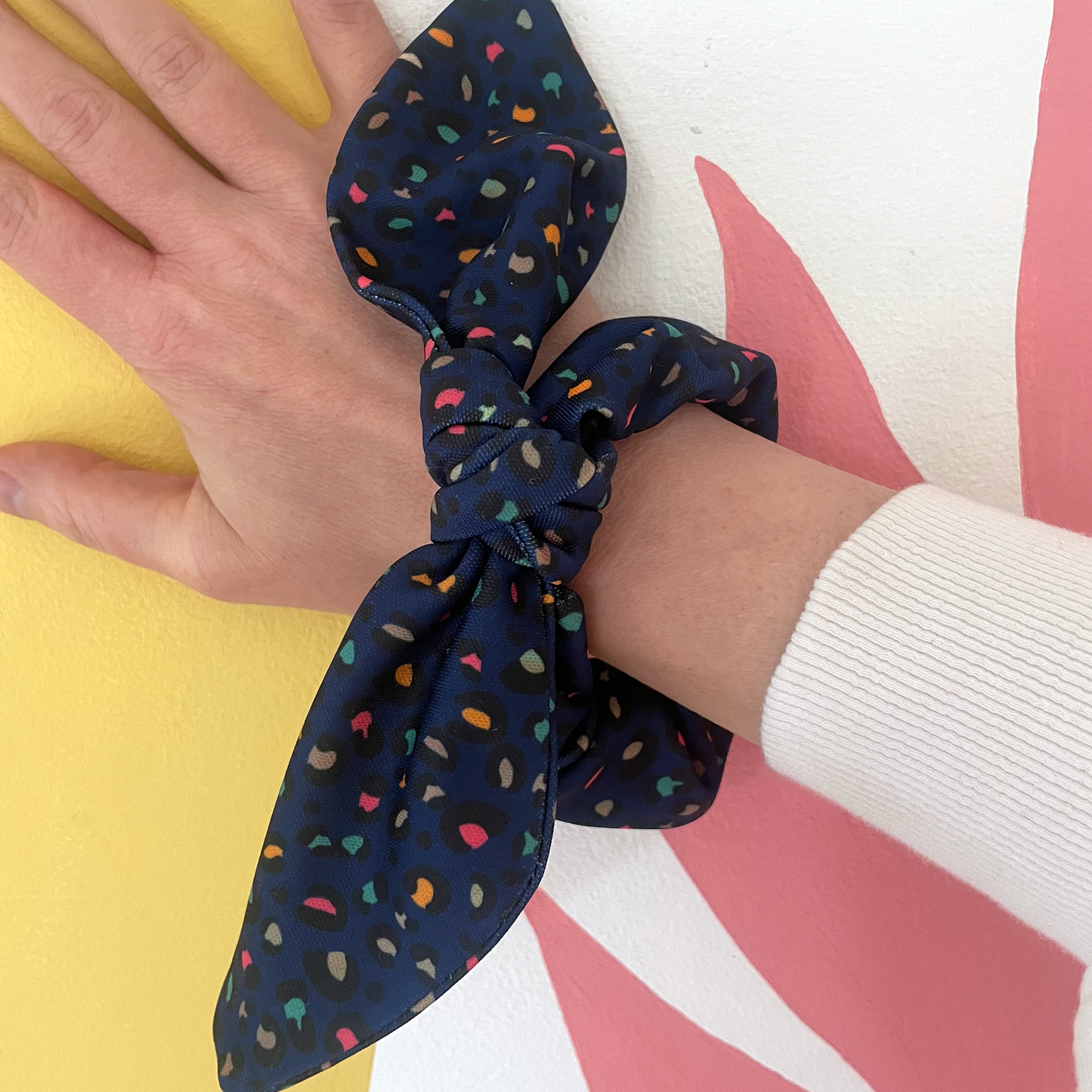 Image shows a handmade midnight blue leopard print hair scrunchie with a bow.