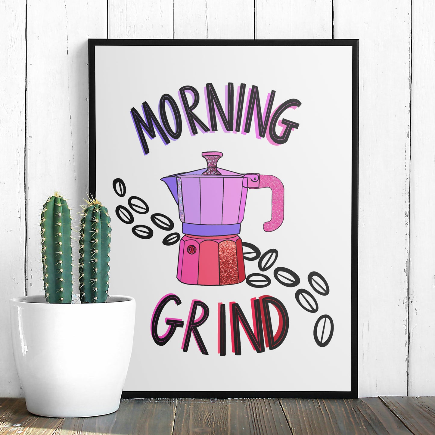 Image shows a framed illustration of a stovetop espresso maker in shades of pink and purple with ink drawn coffee beans behind it. Modern graphic lettering reads Morning Grind.