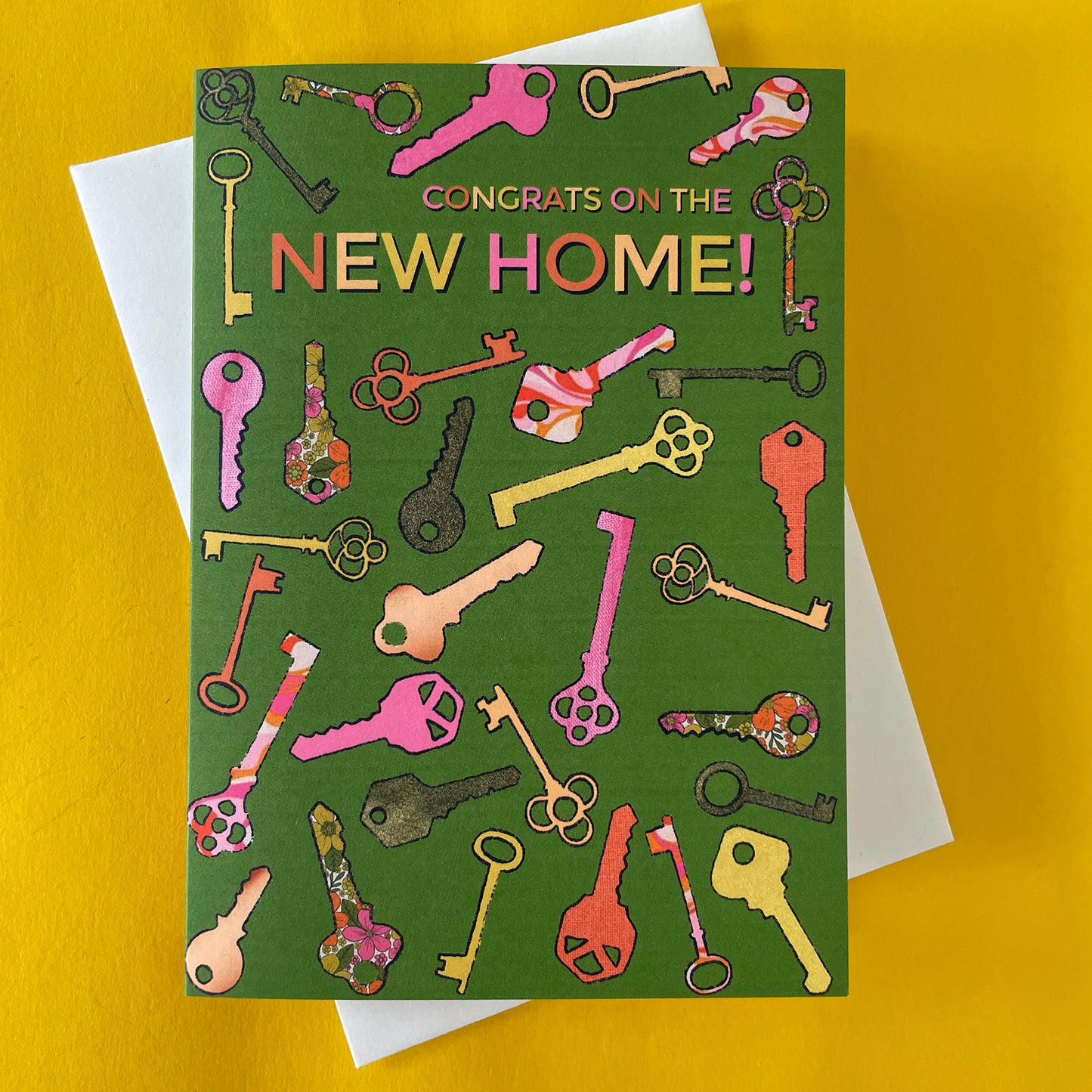 Image shows a green greetings card with a illustrations of colourful keys and the words 'Congrats on the new home'