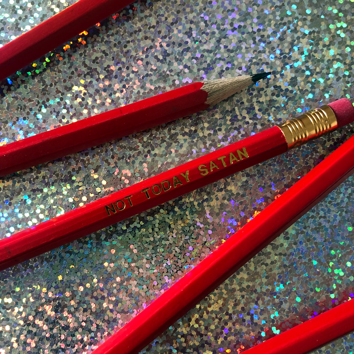 Image of a pencil in bright red with lettering embossed in gold with the wording 'not today satan'
