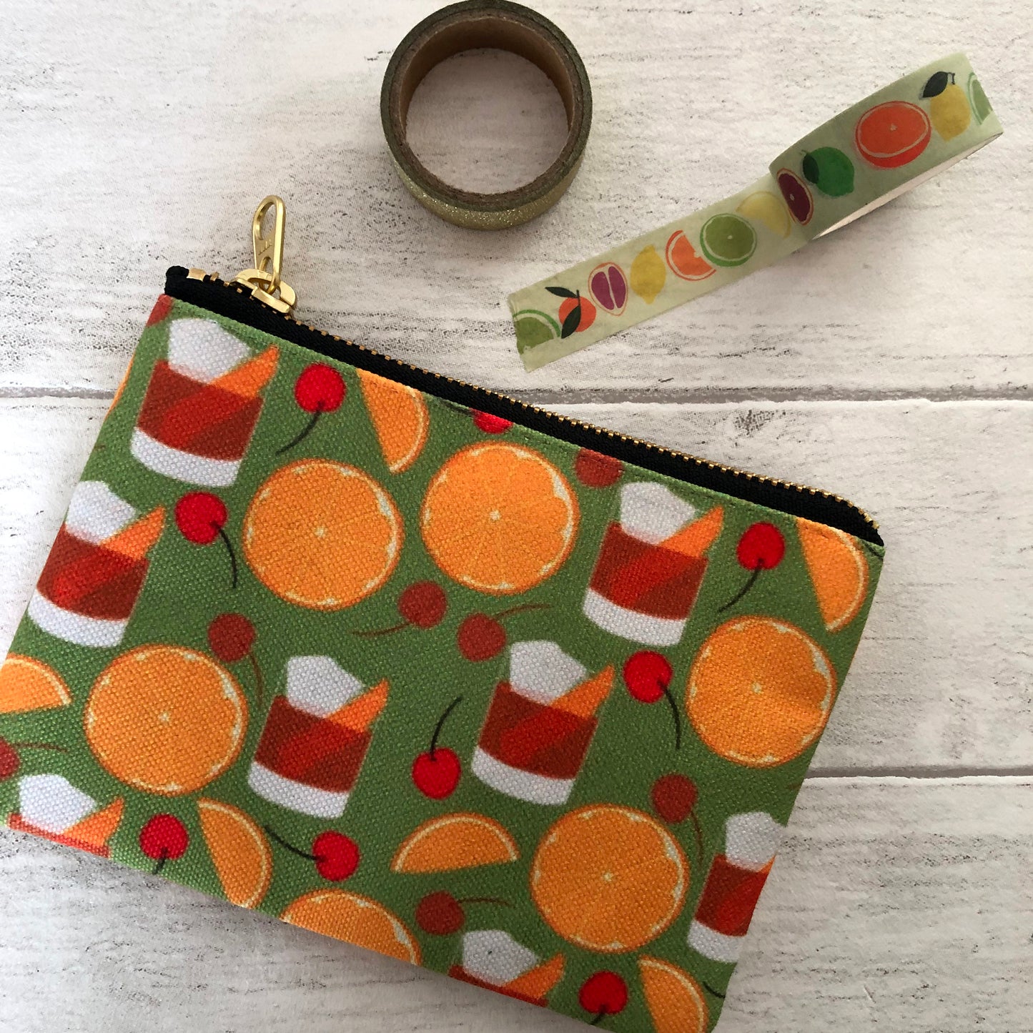 Image shows a handy zip pouch featuring a fun retro old fashioned cocktail inspired design
