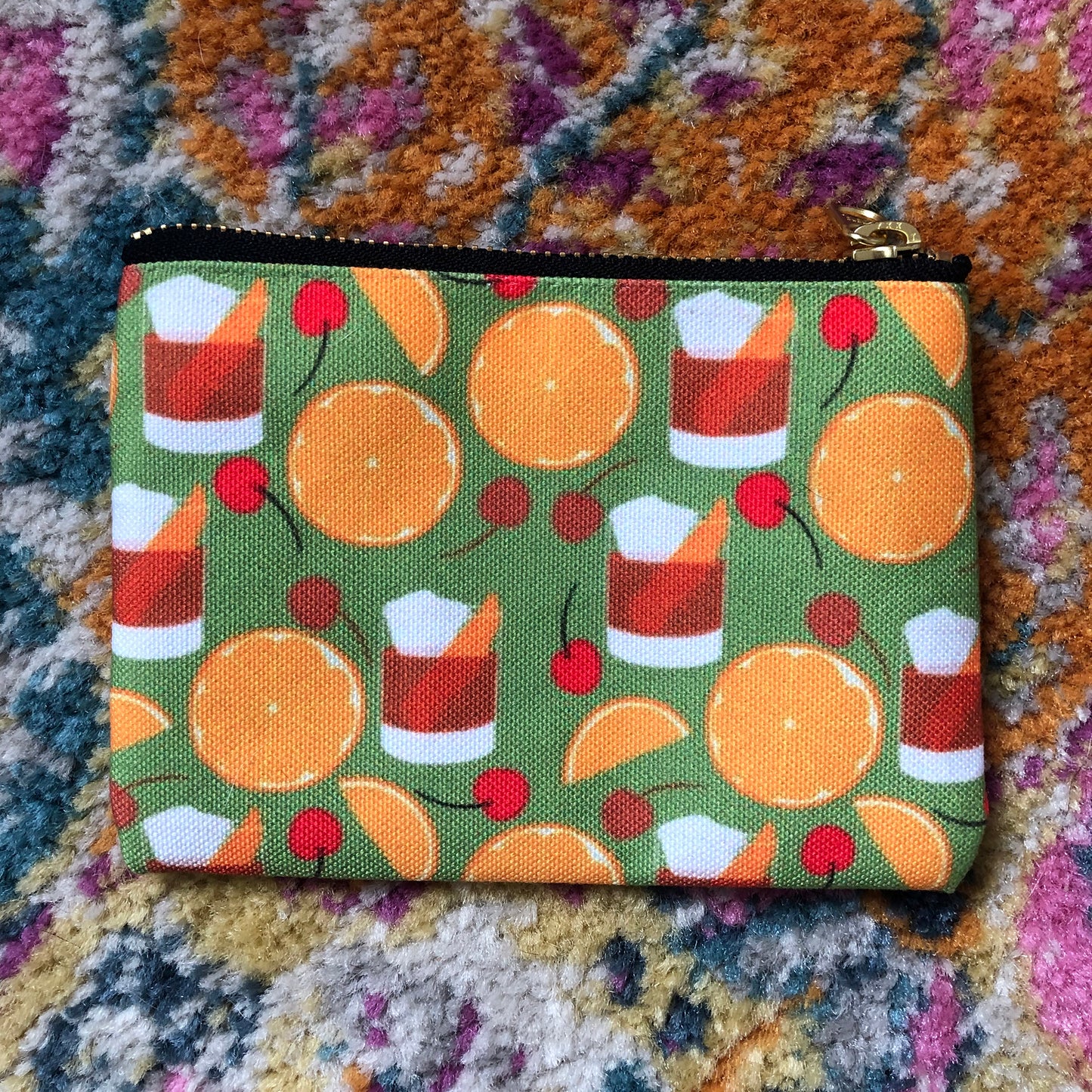 Image shows a handy zip pouch featuring a fun retro old fashioned cocktail inspired design